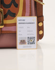 Gold & Beyond Burberry buckle crossbody handbag with adjustable strap and classic check pattern, stylishly displayed.