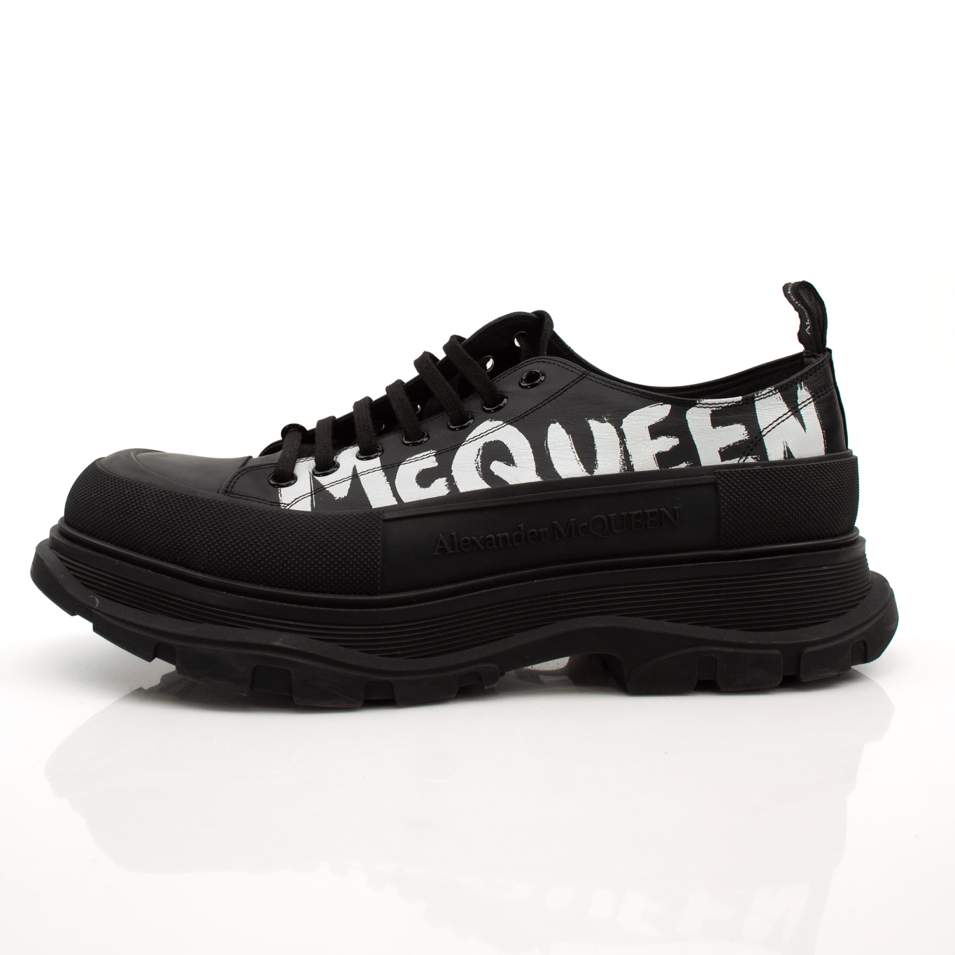 Gold & Beyond Alexander McQueen oversized sneakers featuring bold design, white leather upper, chunky sole, and distinctive lacing.