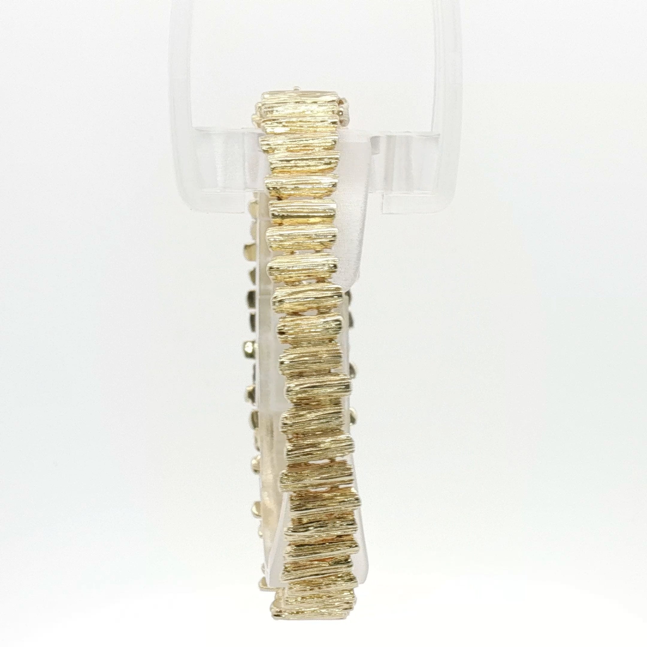 14K yellow gold brutalist textured bangle bracelet with modern, artistic design, showcasing unique craftsmanship and bold style.