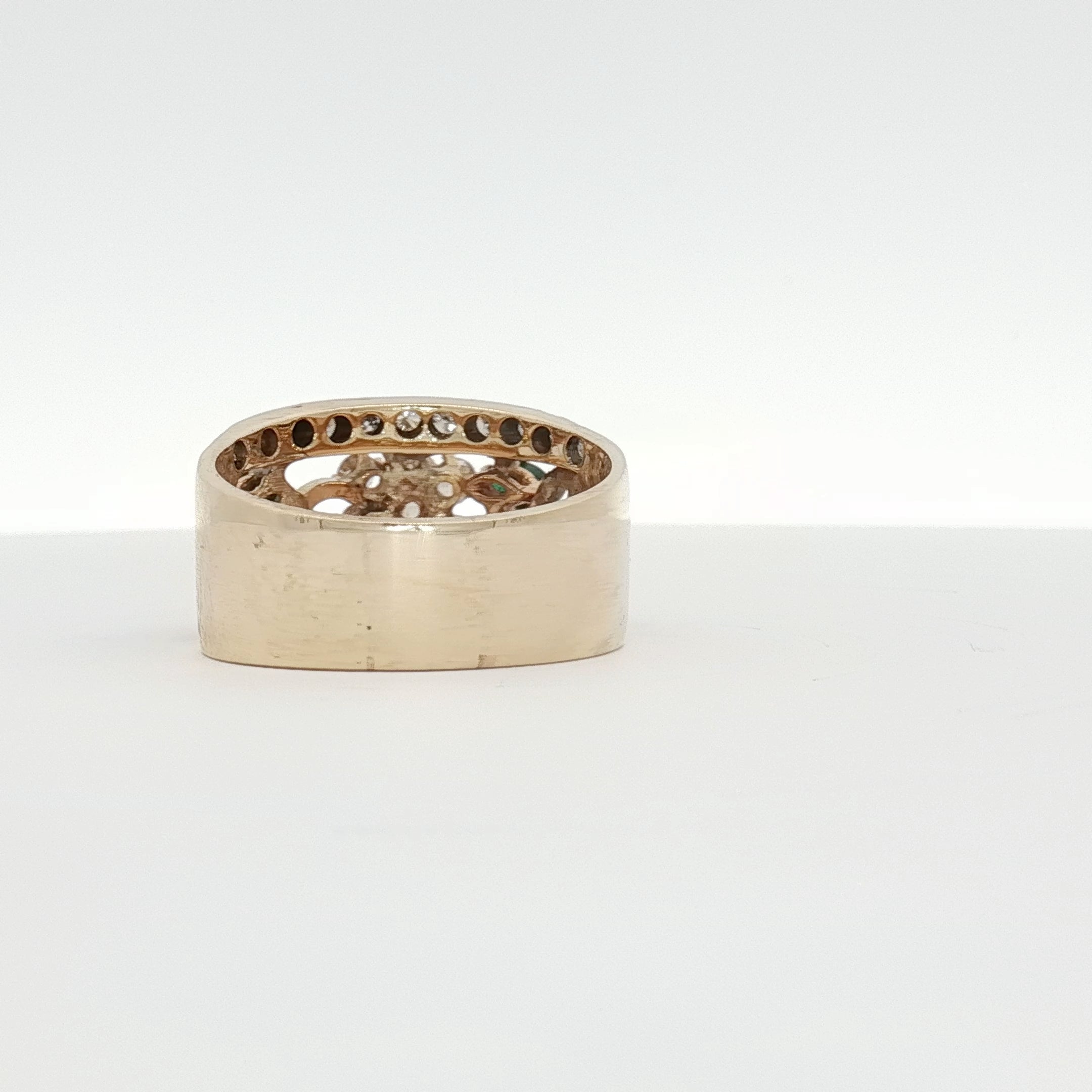 Yellow gold emerald and diamond flower cluster ring with intricate design, showcasing luxurious jewelry craftsmanship.