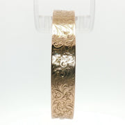 14K yellow gold engraved floral bangle bracelet with detailed floral design, crafted by Gold & Beyond.