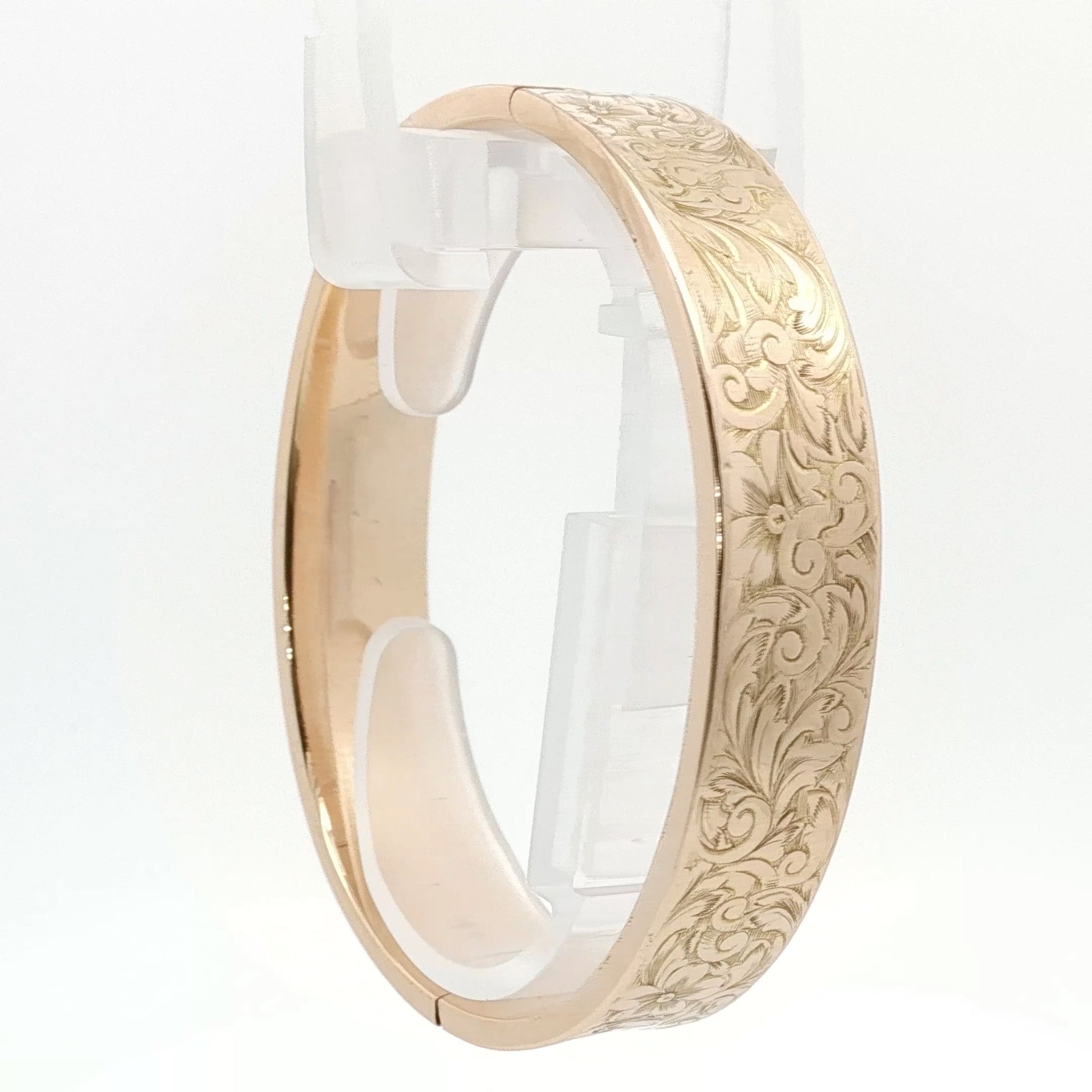 14K yellow gold engraved floral bangle bracelet, showcasing intricate floral patterns and polished finish.