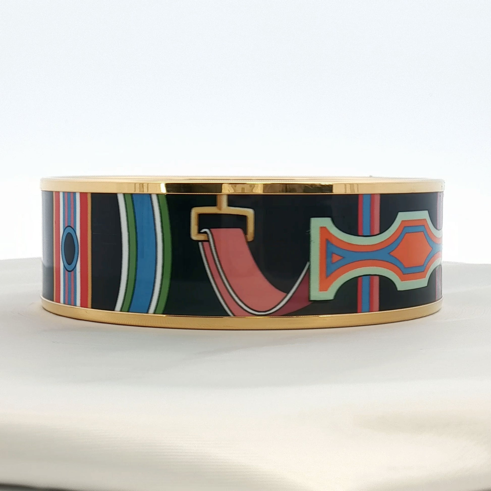 Hermès enamel bangle bracelet in vibrant colors, showcasing elegant jewelry design with gold accents and smooth enamel surface.
