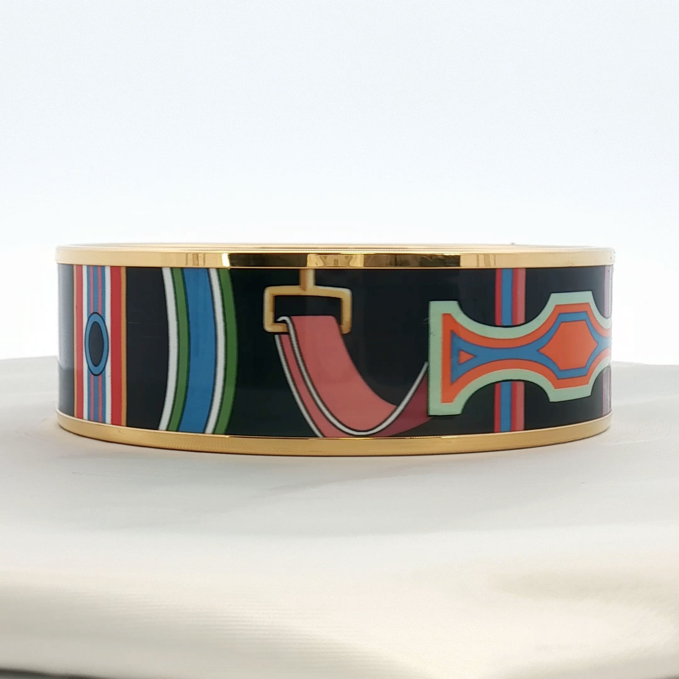 Hermès enamel bangle bracelet in vibrant colors, showcasing elegant jewelry design with gold accents and smooth enamel surface.