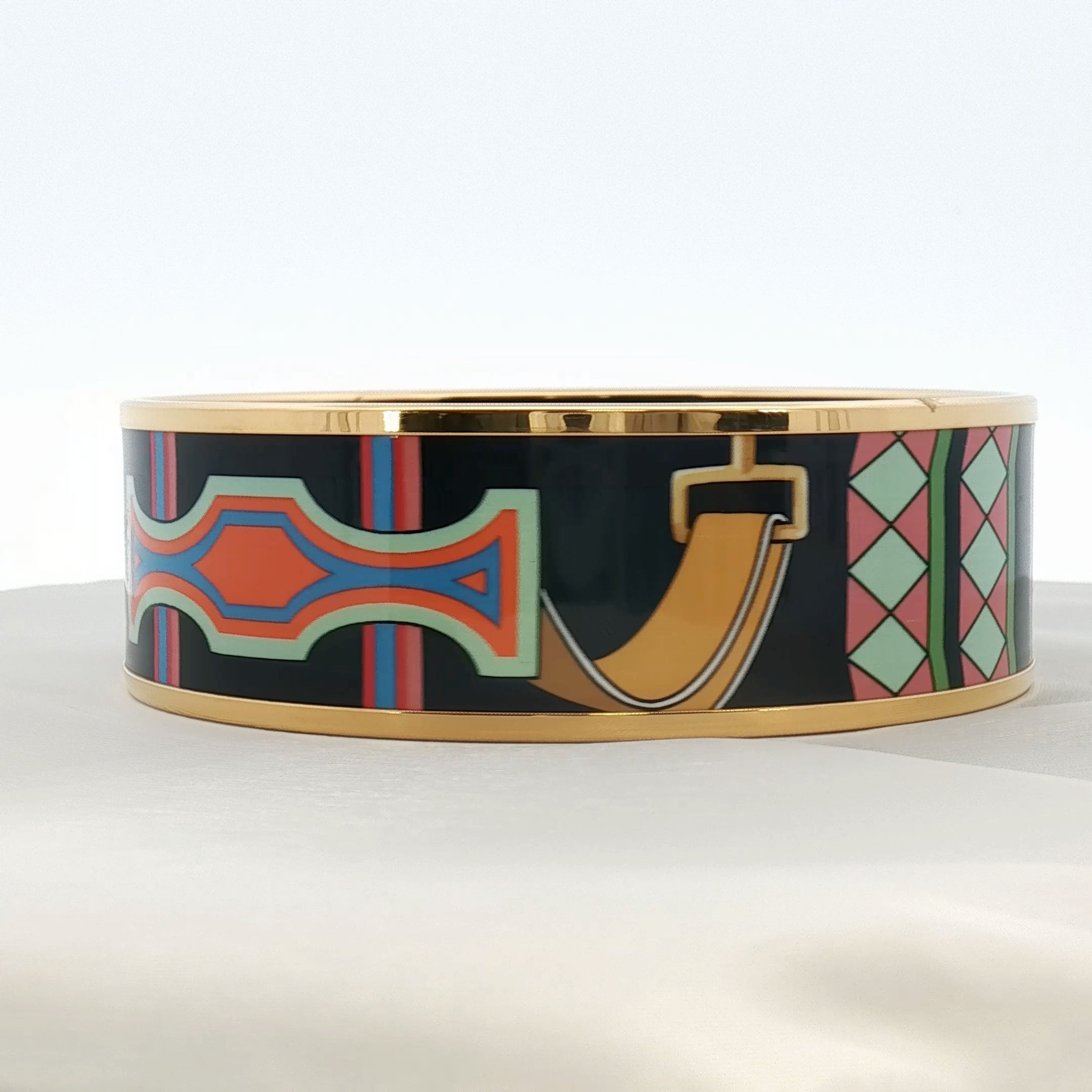 Hermès enamel bangle bracelet featuring colorful enamel in gold-tone jewelry design by Gold & Beyond.
