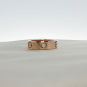 Cartier Love diamond ring shown in gold jewelry with embedded sparkling diamonds on a white background.