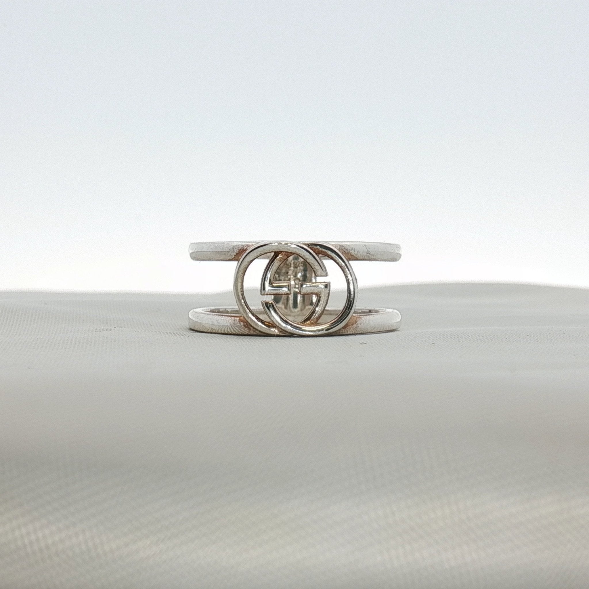 Sterling silver Gucci GG ring, stylish jewelry piece with engraved logo, showcasing elegant design and craftsmanship.