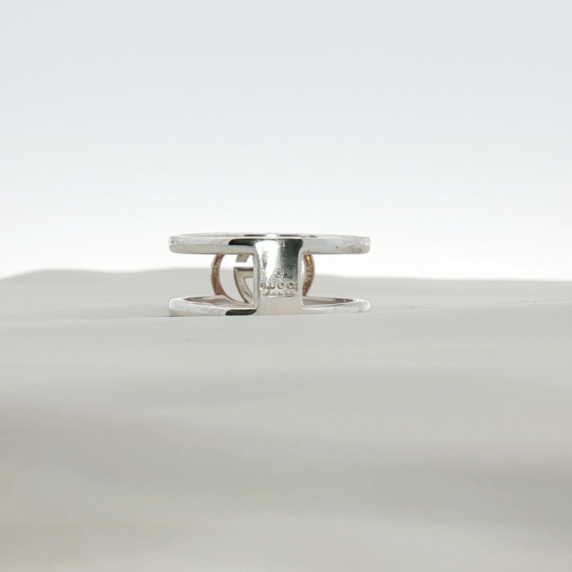 Sterling silver Gucci GG jewelry ring with engraved logo, displayed on a neutral background.