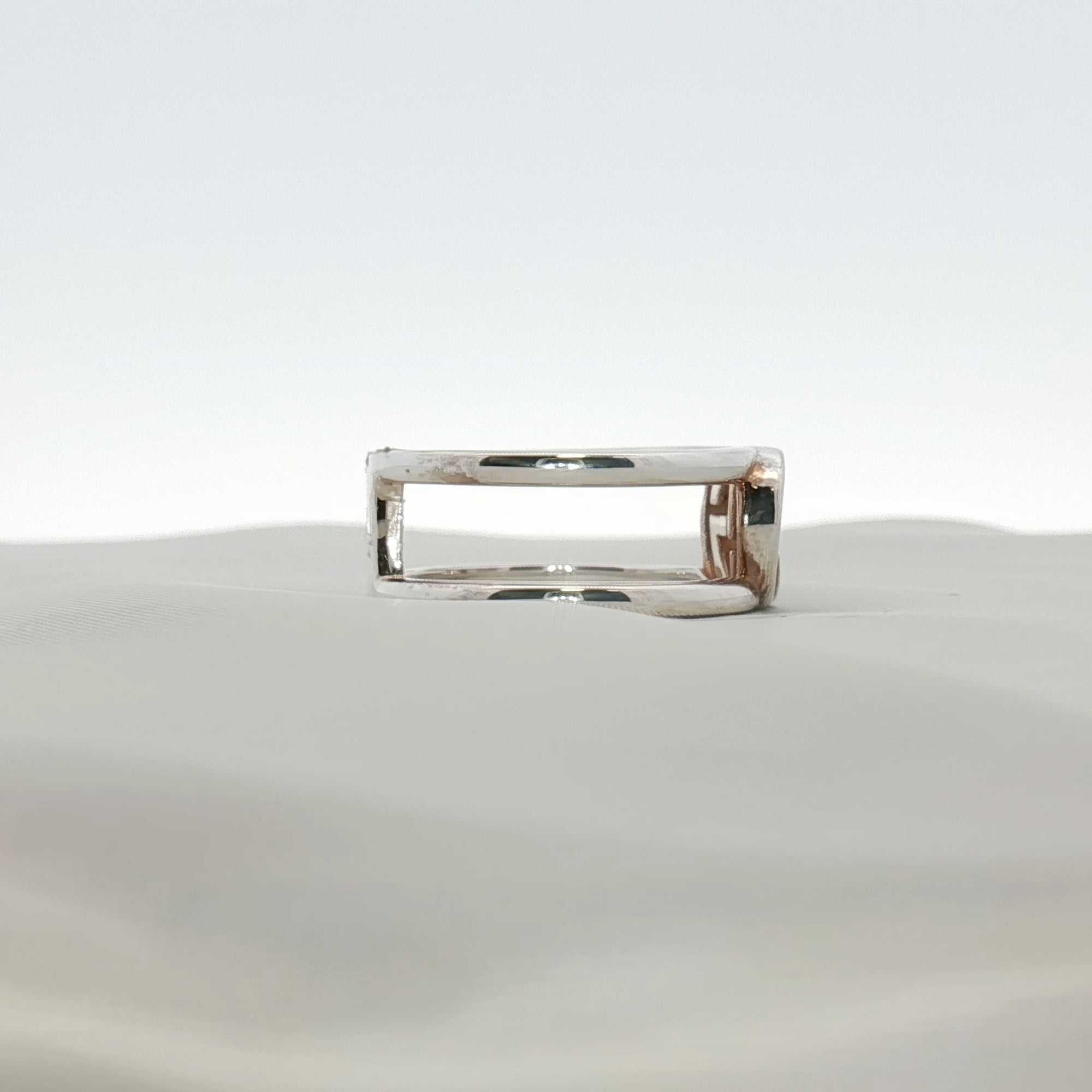 Sterling silver Gucci GG jewelry ring with engraved logo, stylish accessory displayed on a neutral background.