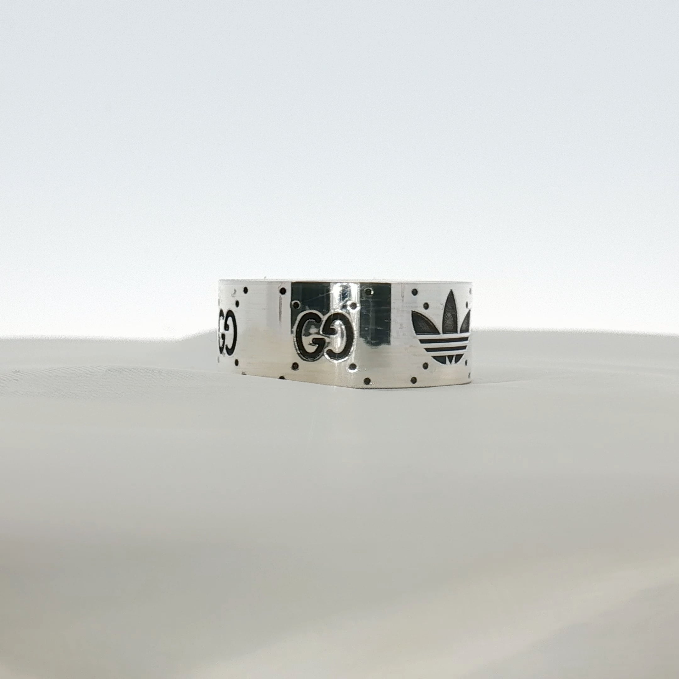 Gold & Beyond Gucci x Adidas logo band ring, jewelry piece featuring the iconic brand logos on a sleek band.