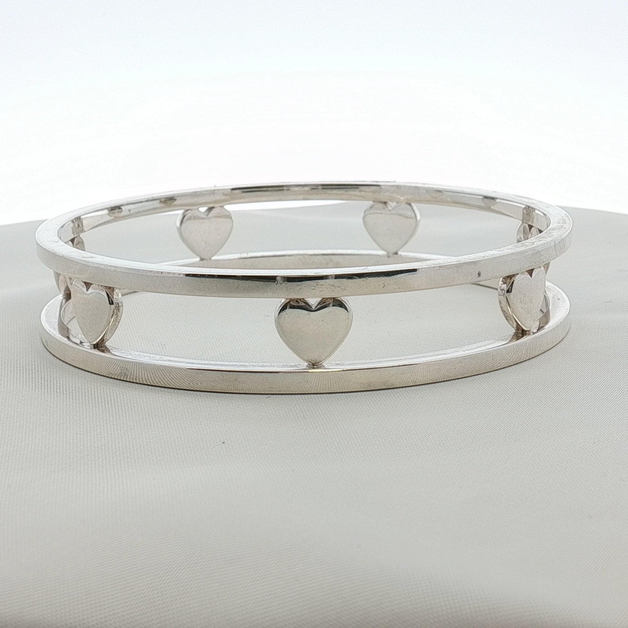 Sterling silver heart bracelet by Tiffany & Co. featuring a delicate chain and heart pendant, shown on a neutral background.