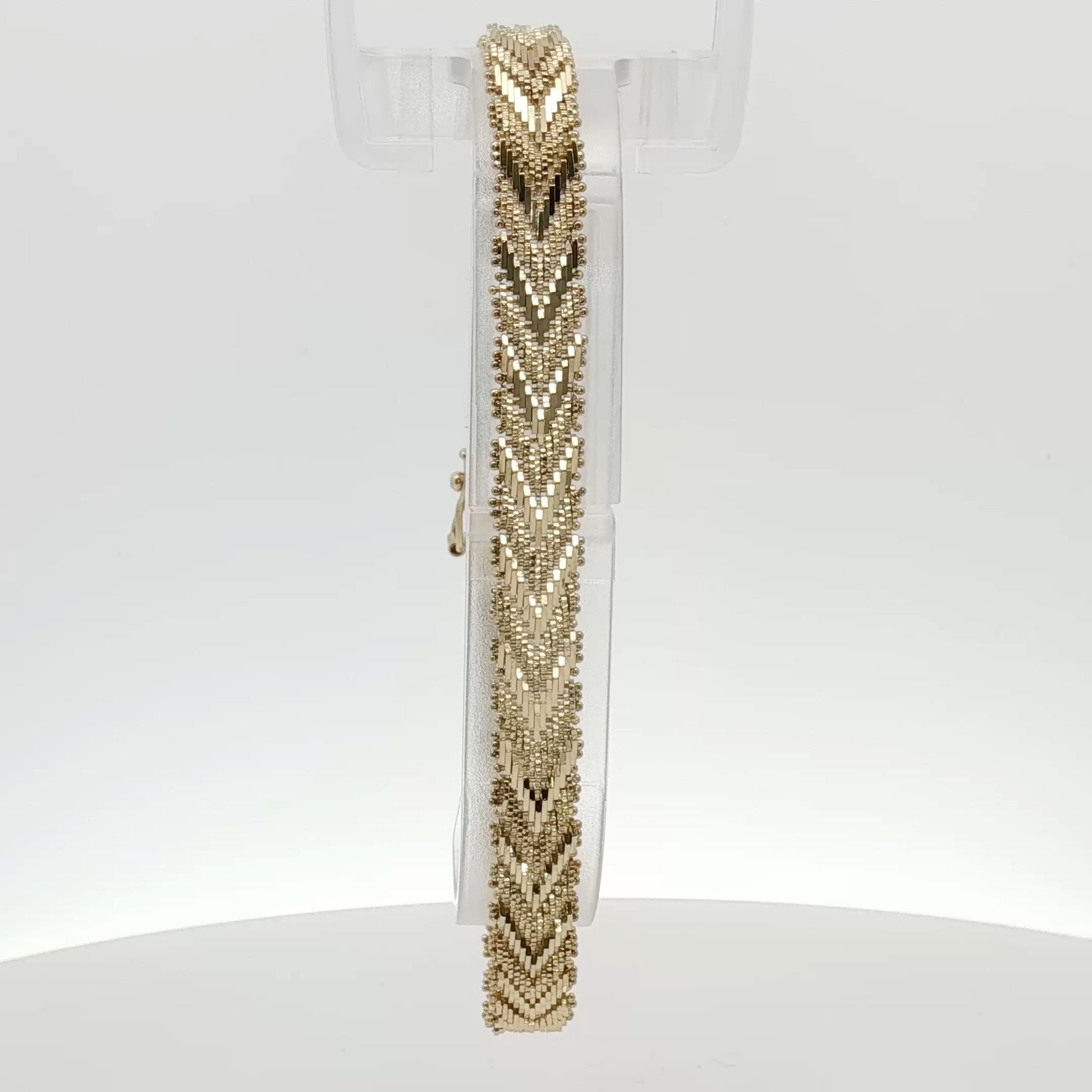 14K yellow gold textured link bracelet with a polished finish, showcasing intricate jewelry craftsmanship.