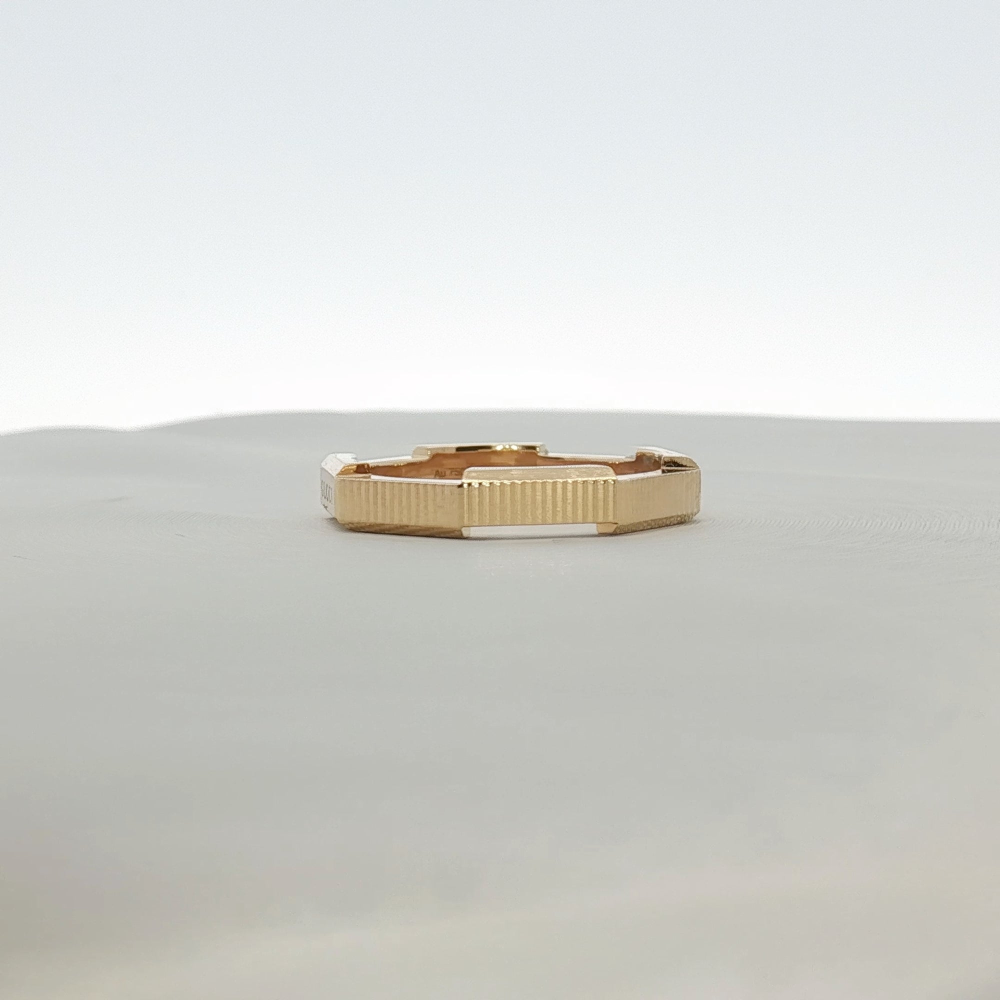 Gold & Beyond Gucci Link to Love striped jewelry ring with colorful design and sleek metal band on a white background.