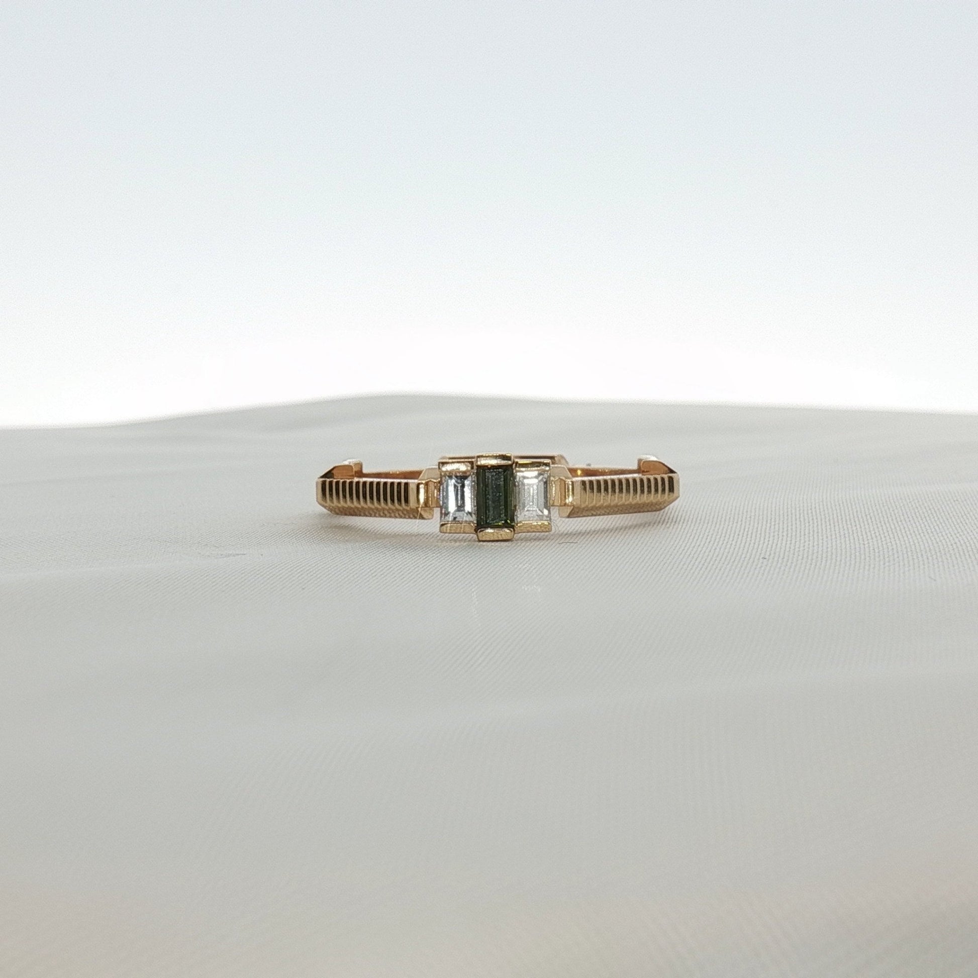 Gucci emerald and diamond jewelry ring with gold band, featuring vibrant green gemstone and sparkling diamonds.