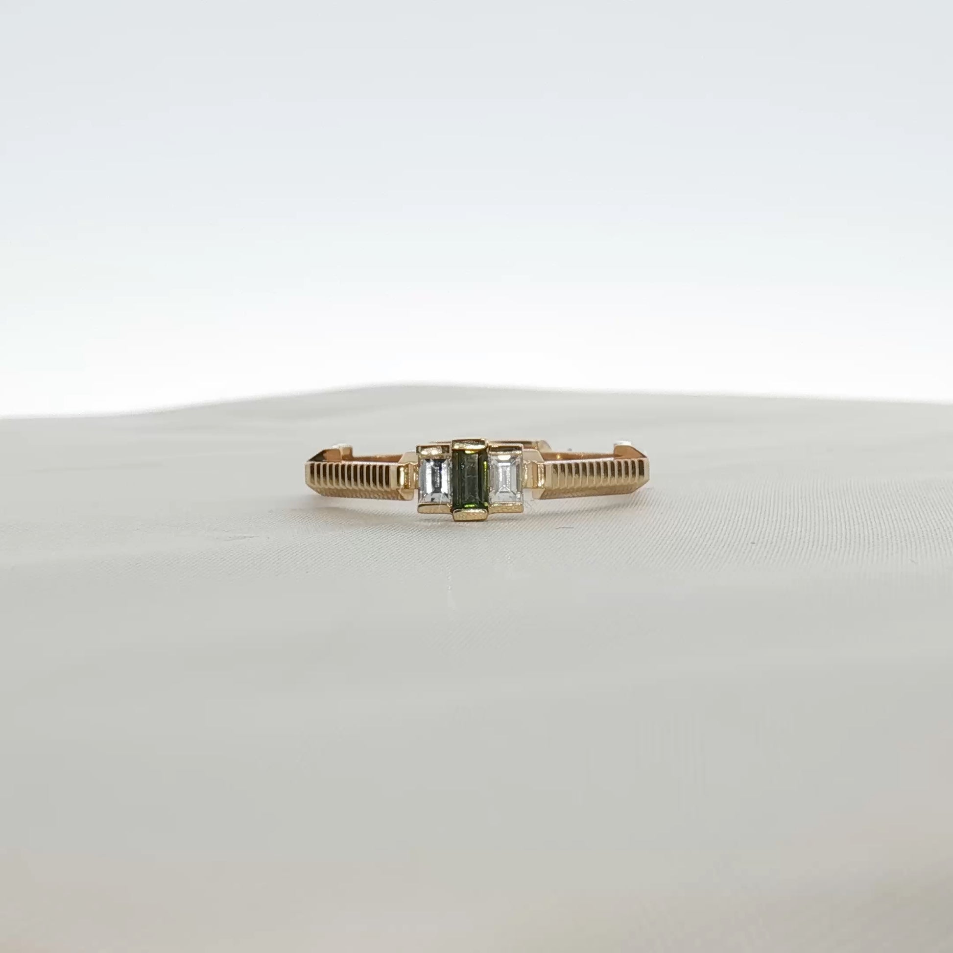 Gucci emerald and diamond jewelry ring with gold band, featuring vibrant green gemstone and sparkling diamonds.