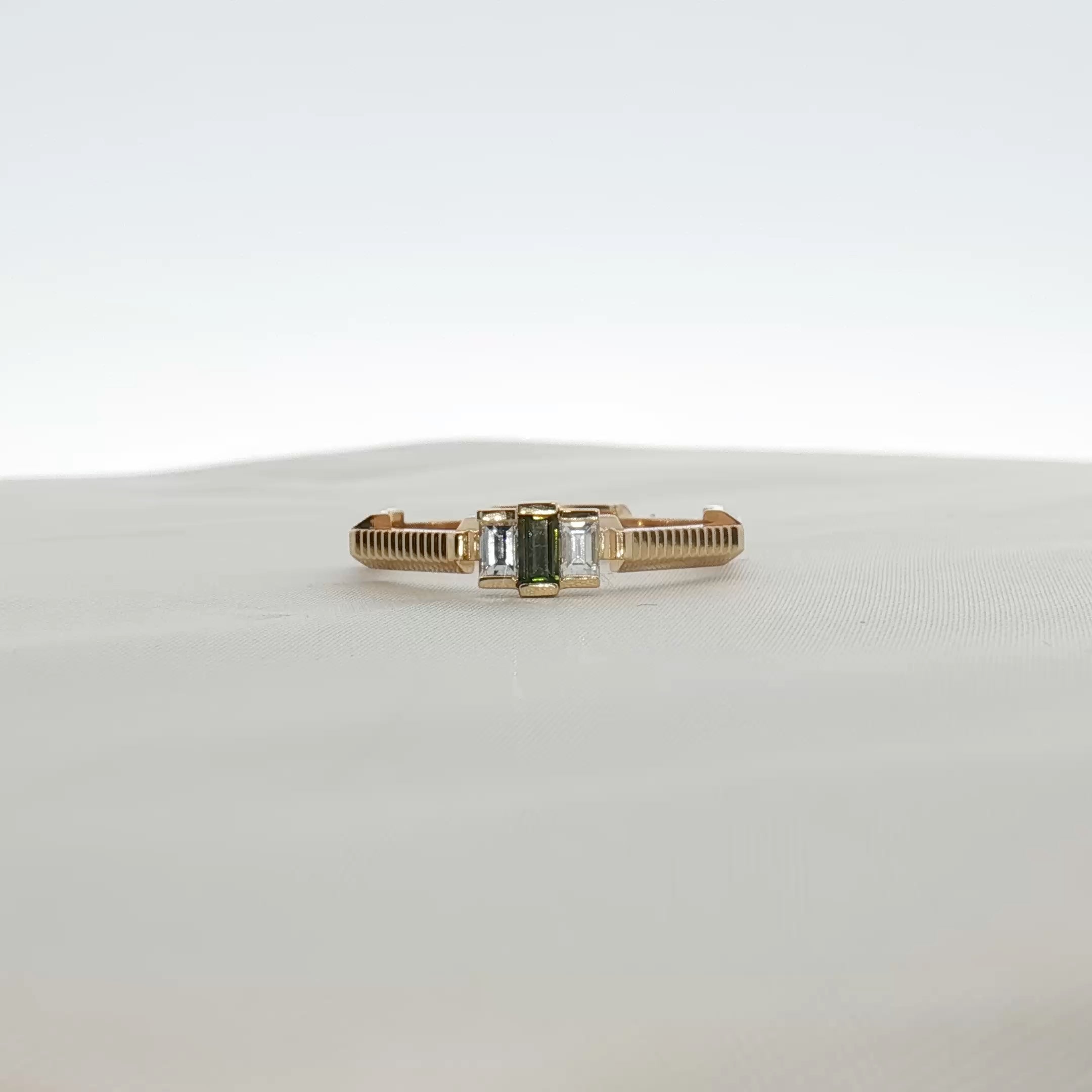 Gucci emerald and diamond jewelry ring with gold band, featuring vibrant green gemstone and sparkling diamonds.