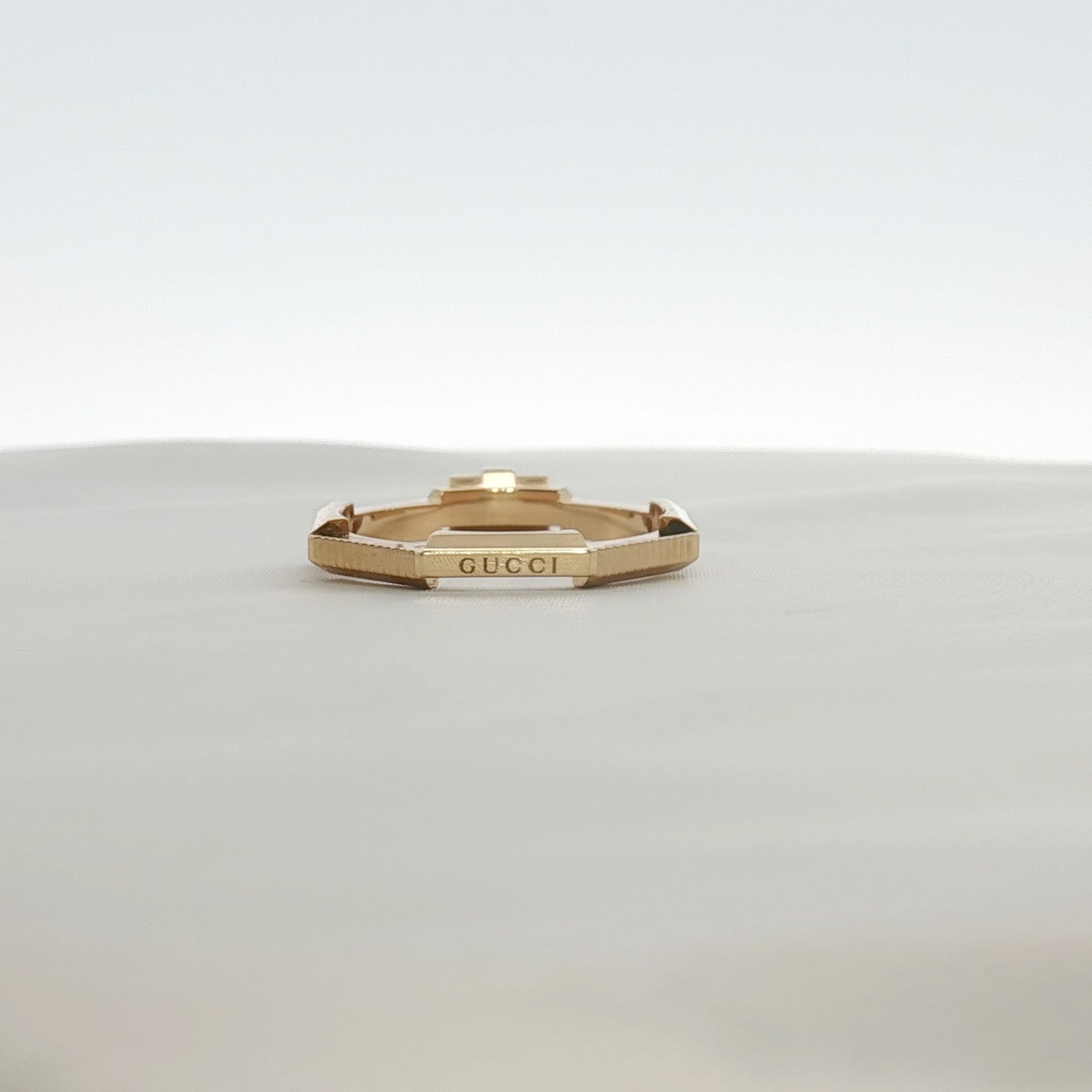 Gucci emerald and diamond jewelry ring with gold setting, featuring vibrant emerald and sparkling diamonds on a sleek band.