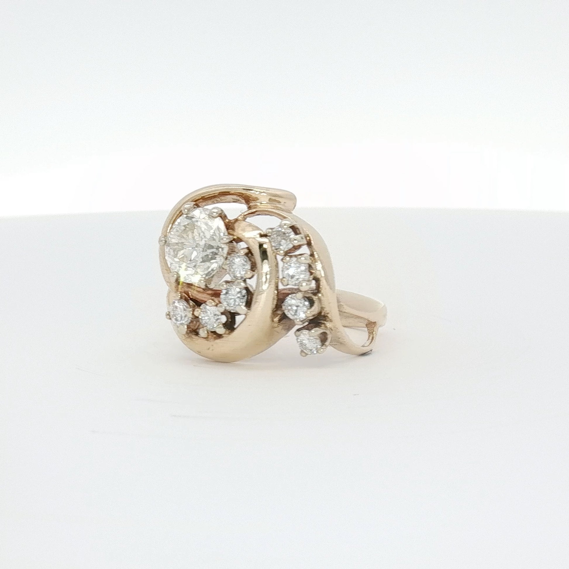 14K yellow gold diamond swirl ring, elegant jewelry piece with sparkling diamonds and a flowing design, by Gold & Beyond.