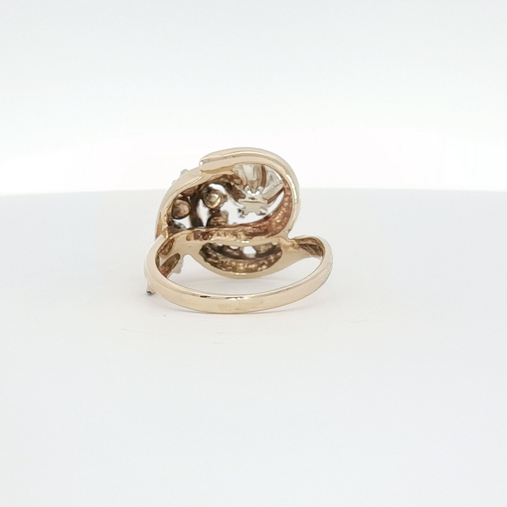 14K yellow gold diamond swirl ring from Gold & Beyond featuring sparkling diamonds and an elegant, flowing design.
