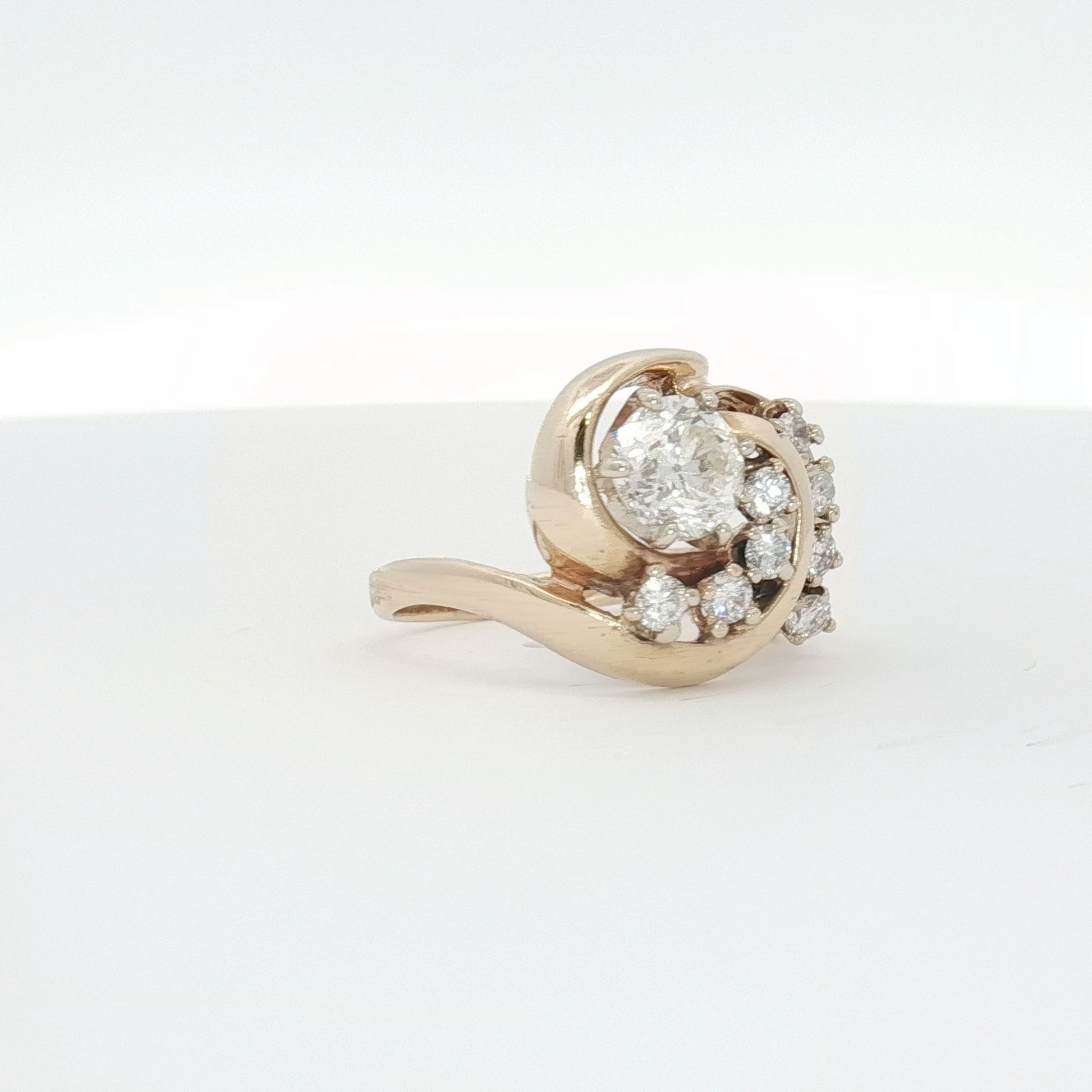 14K yellow gold diamond swirl ring with intricate design, showcasing sparkling diamonds and elegant craftsmanship.
