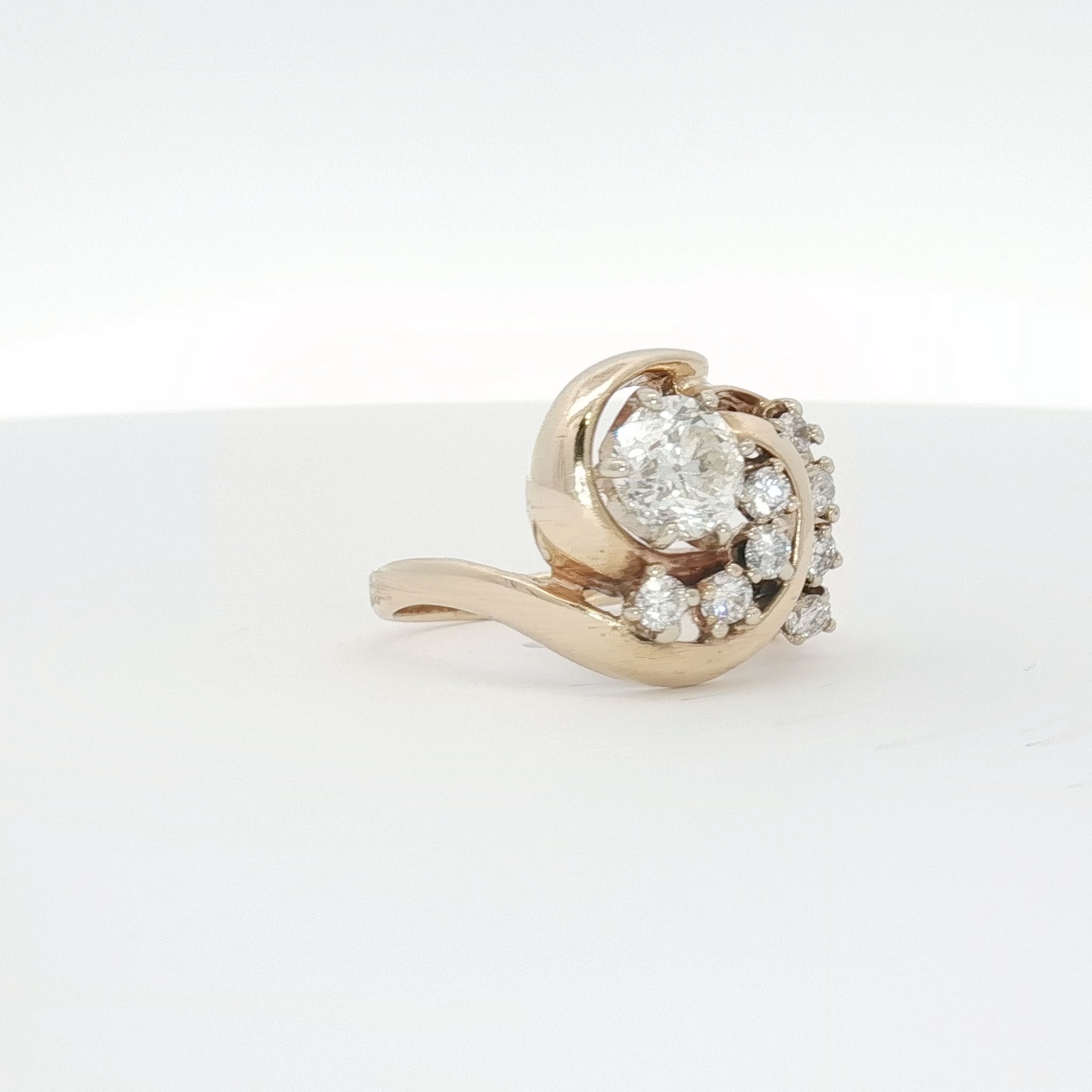 14K yellow gold diamond swirl ring with intricate design, showcasing sparkling diamonds and elegant craftsmanship.