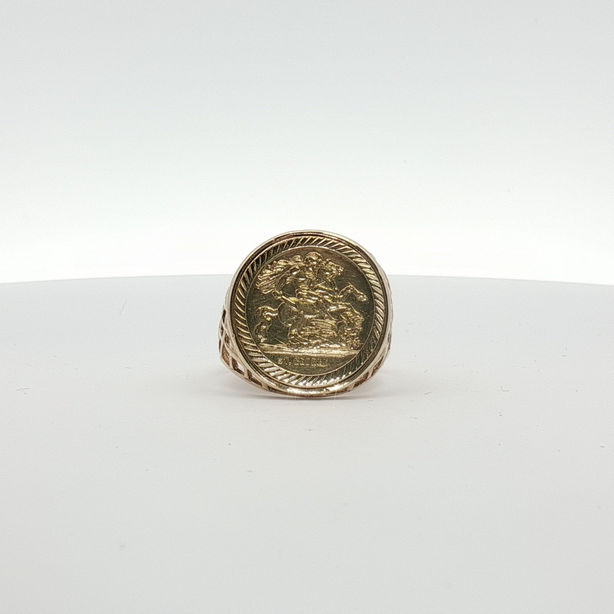9K yellow gold coin ring with detailed engraved design, jewelry piece from Gold & Beyond, showcasing a close-up of the ring's surface.