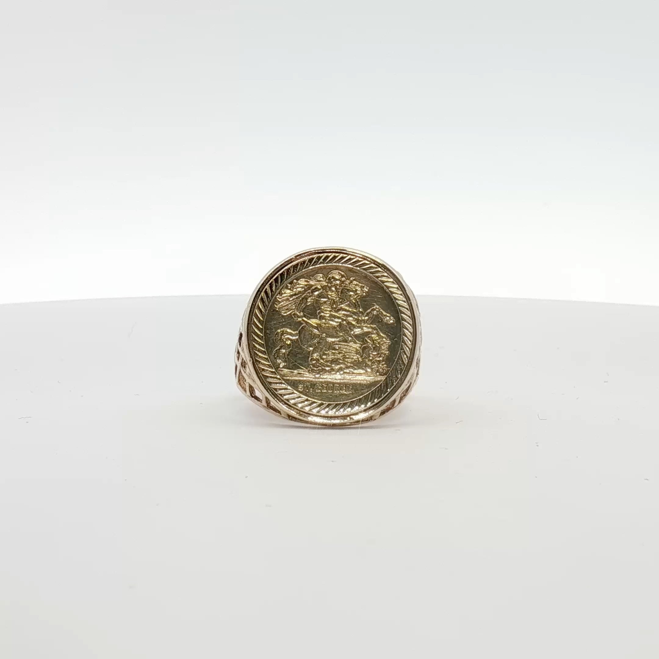 Close-up of 9K yellow gold coin ring with detailed engraved coin design, showcasing fine jewelry craftsmanship.