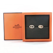 Hermès oval diamond stud earrings in jewelry setting, featuring sparkling diamonds and gold accents on a white background.