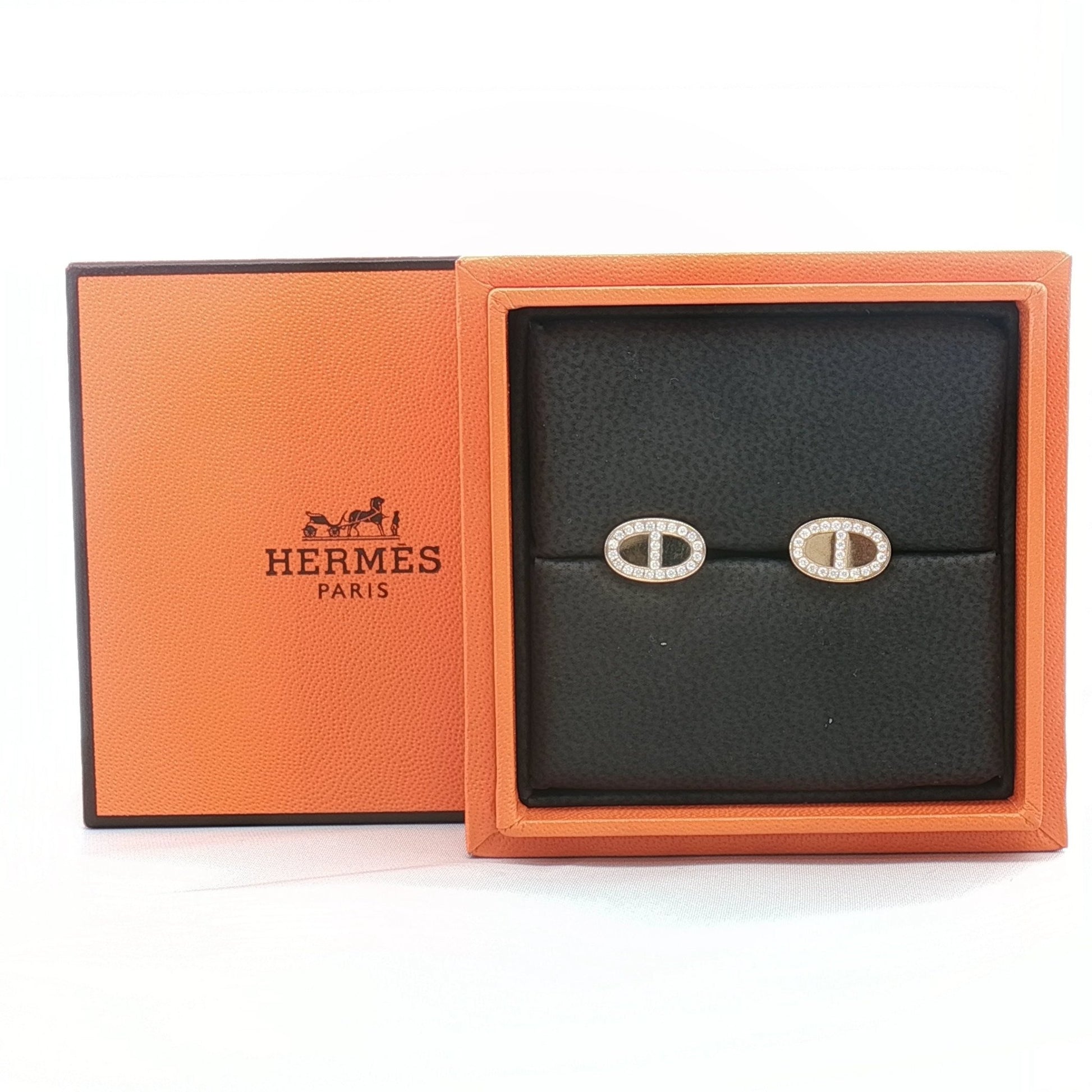 Hermès oval diamond stud earrings in jewelry setting, featuring sparkling diamonds and gold accents on a white background.