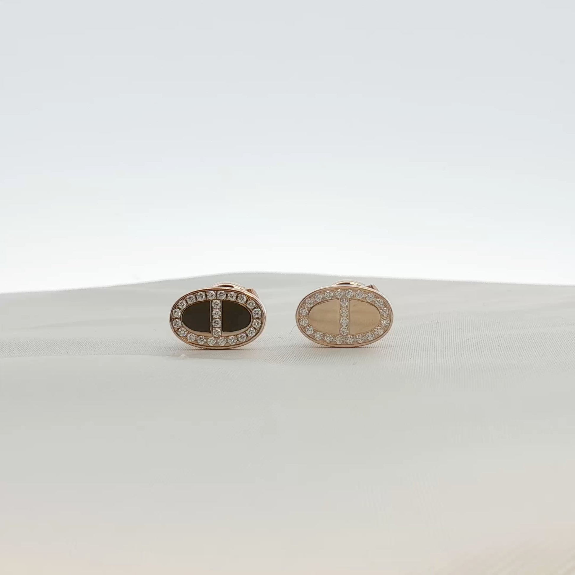 Hermès oval diamond stud earrings in jewelry setting with gold and beyond branding, close-up view of the sparkling earrings.
