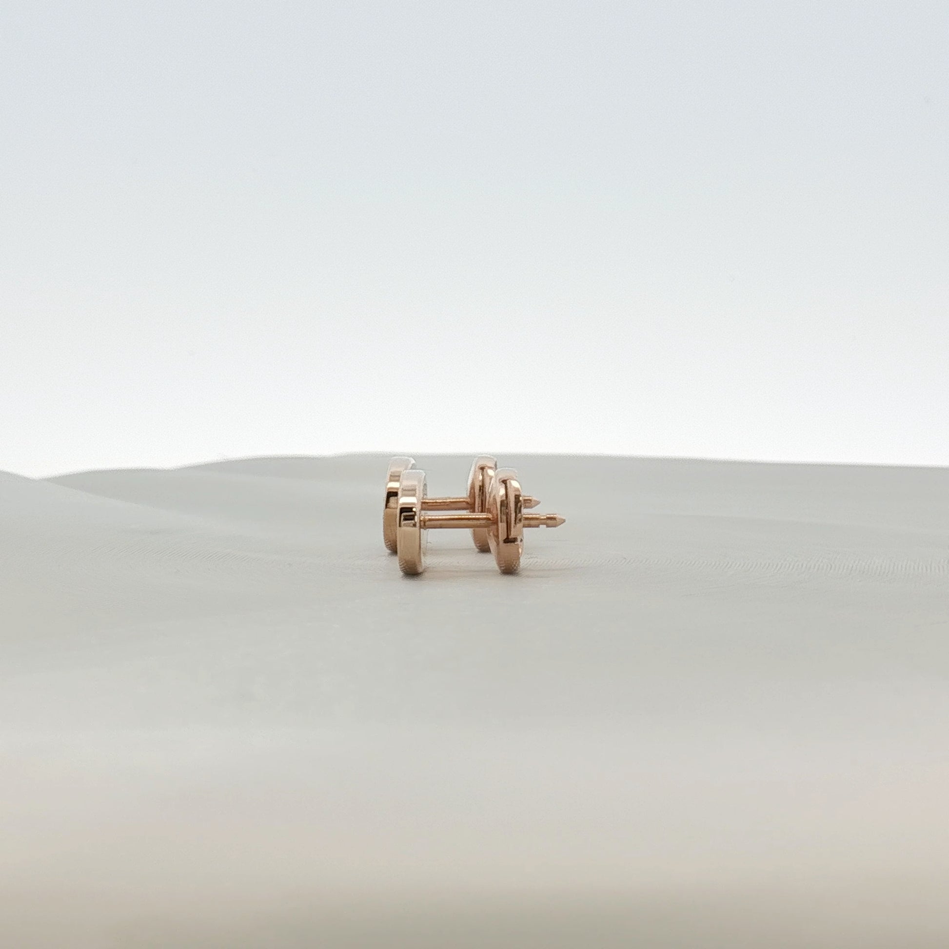 Hermès oval diamond stud earrings in jewelry, showcasing elegant gold settings with sparkling diamonds on a white background.