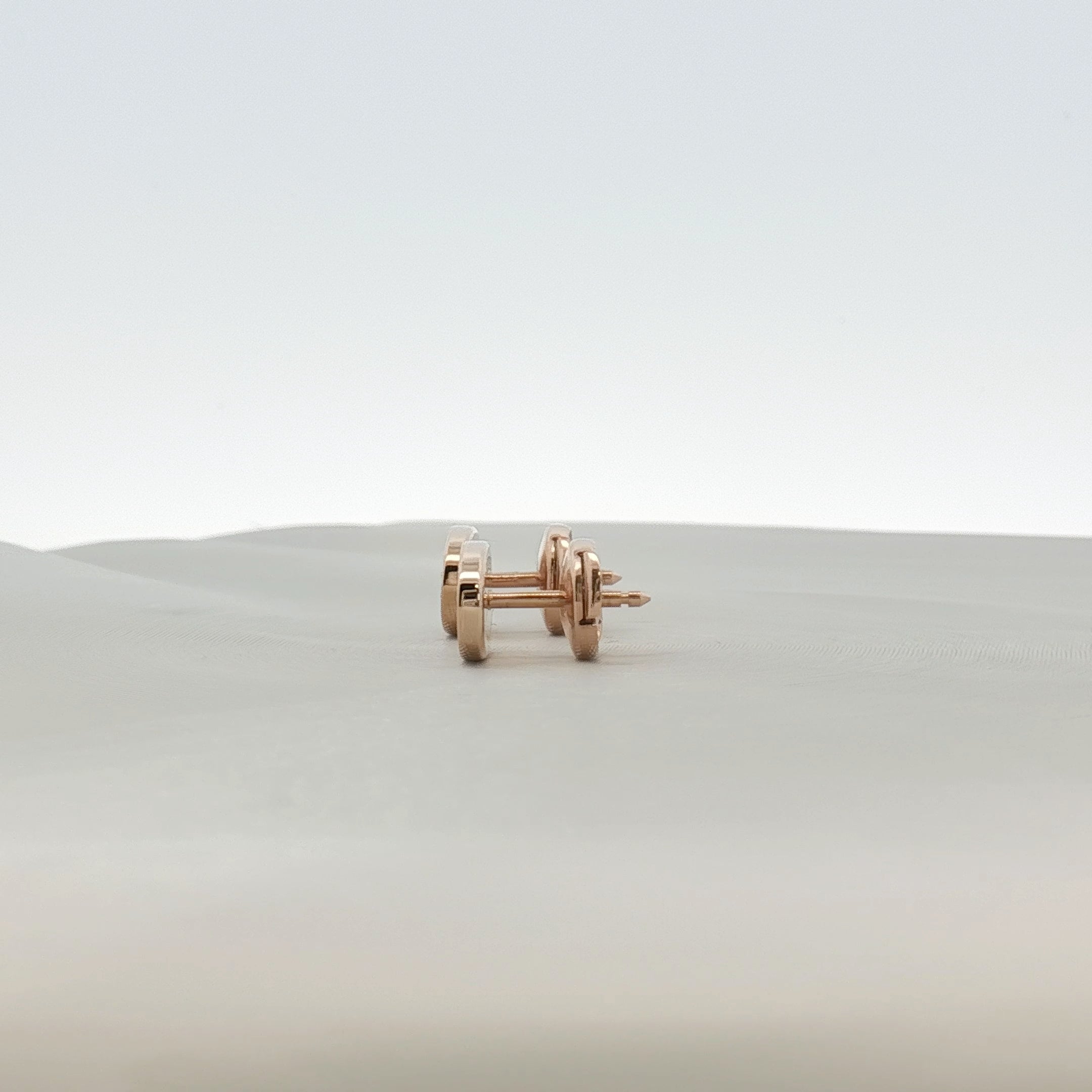 Hermès oval diamond stud earrings in jewelry, showcasing elegant gold settings with sparkling diamonds on a white background.