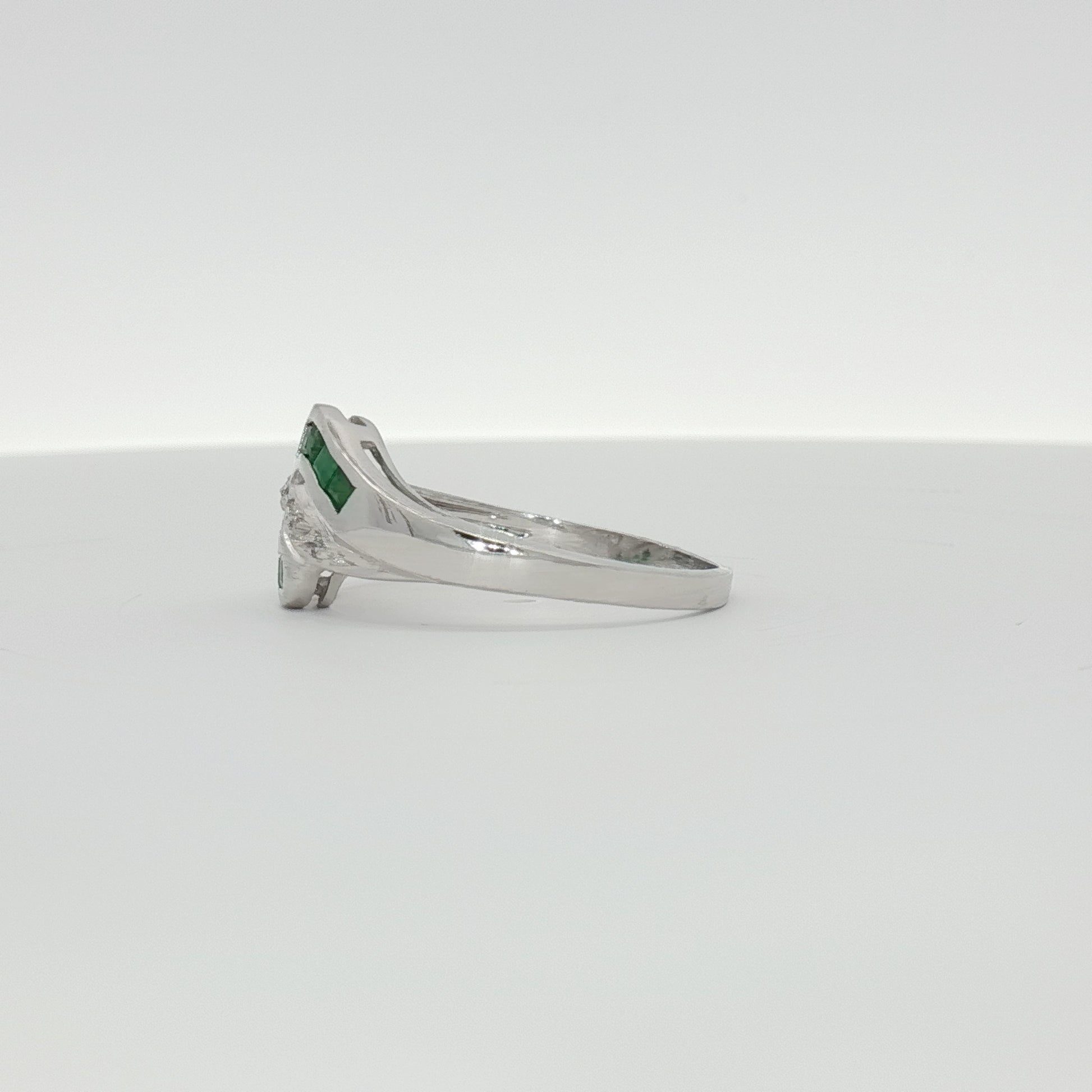 14K white gold emerald and diamond bypass ring featuring sparkling gemstones and sleek jewelry design.