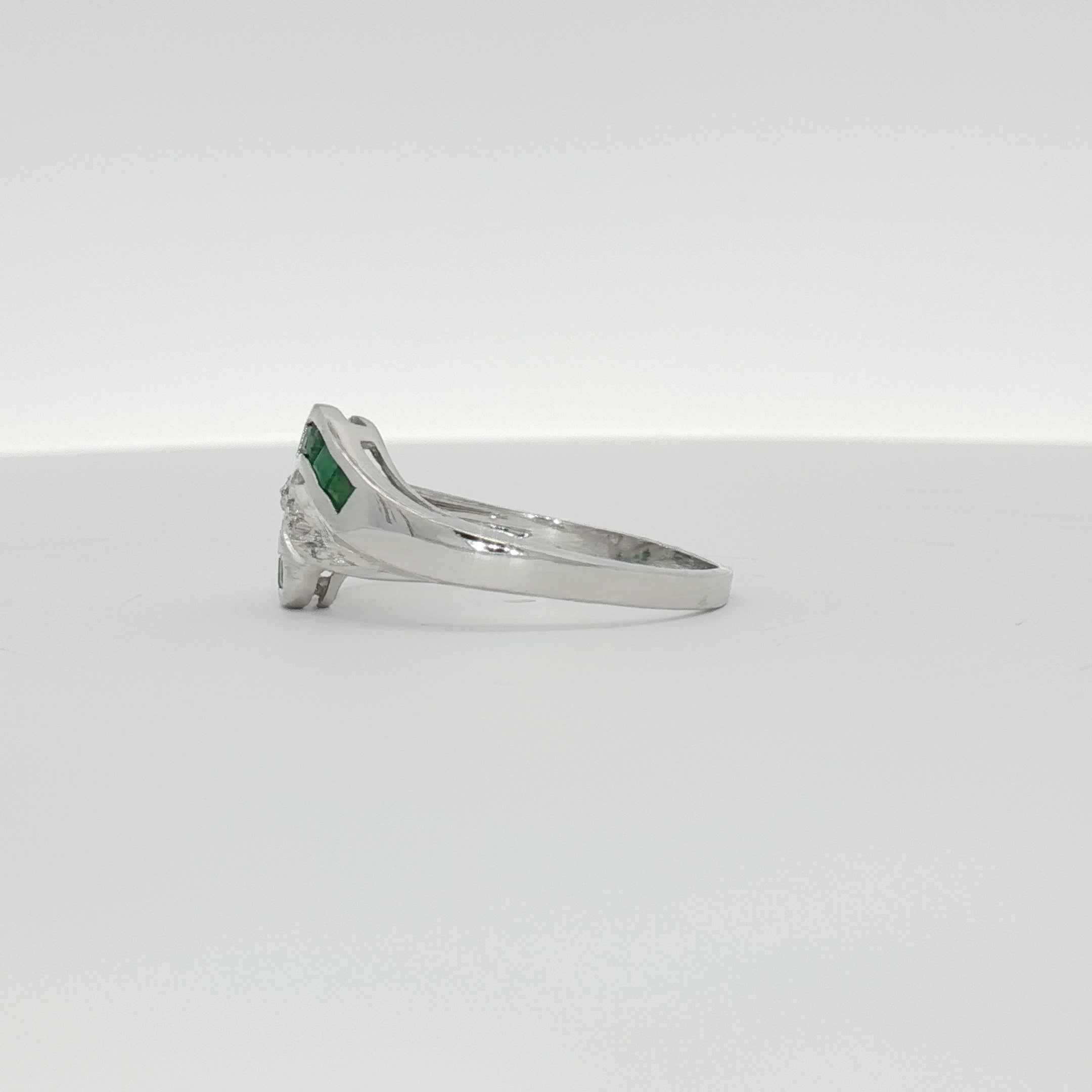 14K white gold emerald and diamond bypass ring featuring sparkling gemstones and sleek jewelry design.