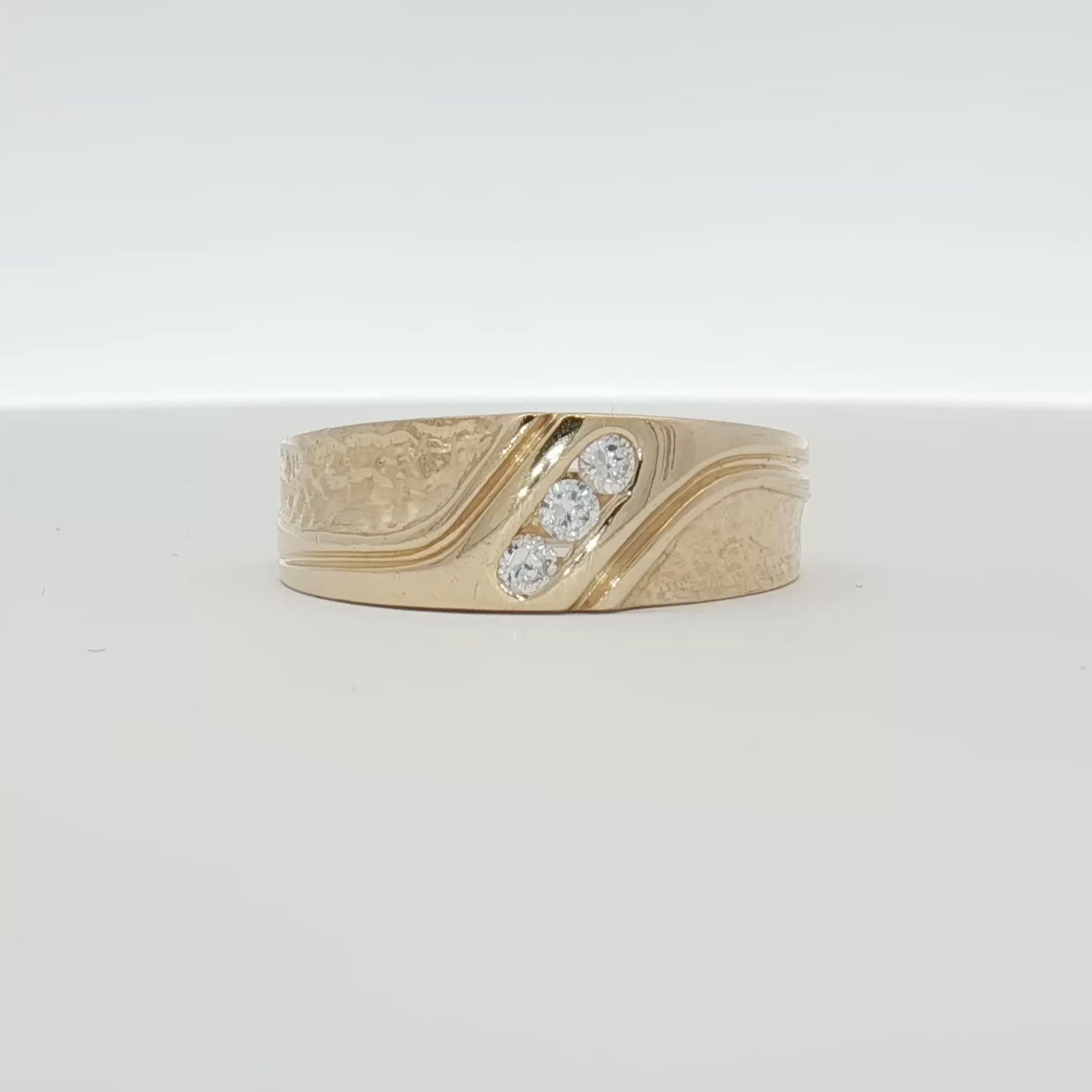 14K yellow gold diamond band ring with sparkling diamonds on a jewelry display showing close-up details.