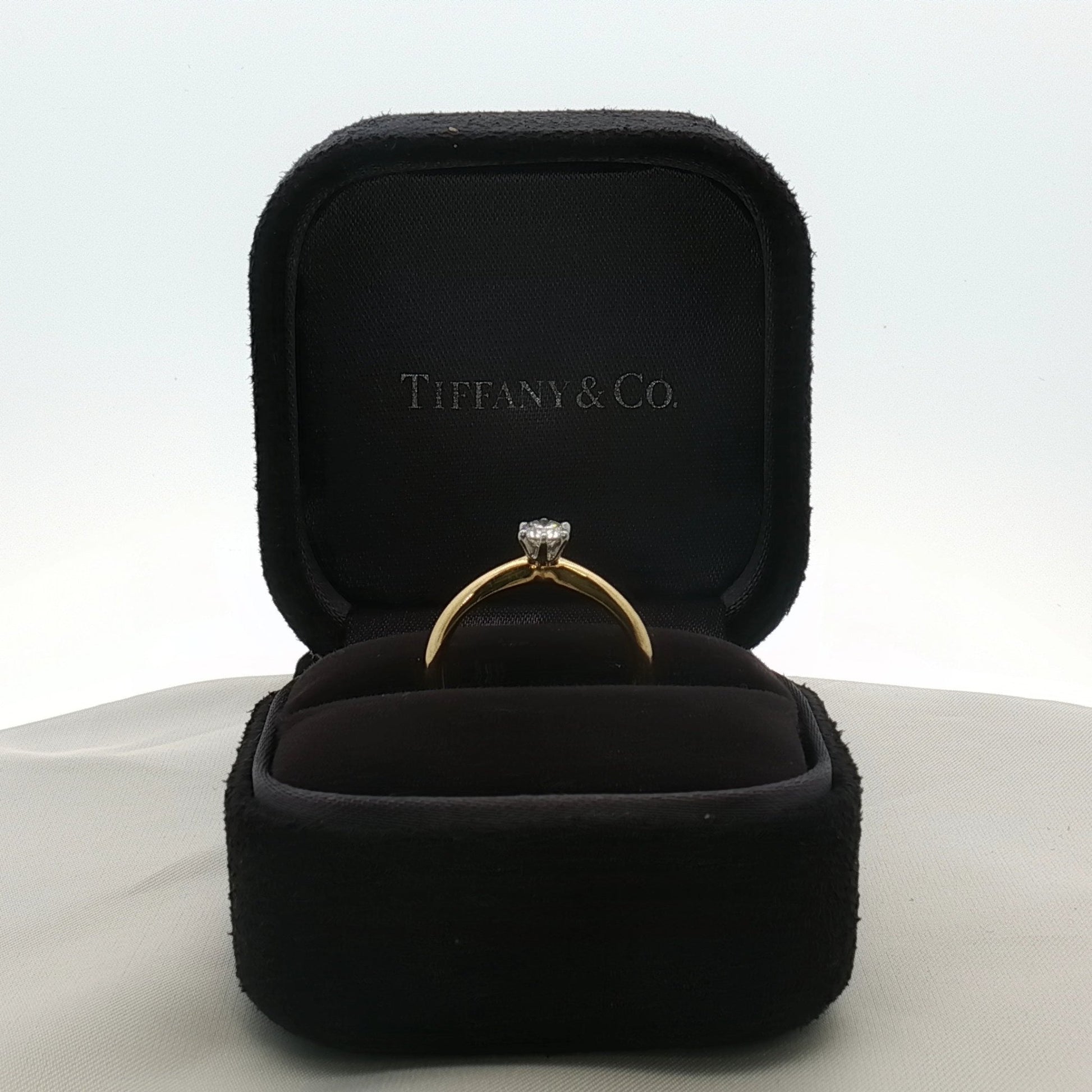 Gold & Beyond Tiffany & Co. classic solitaire diamond jewelry ring with a single sparkling diamond on a sleek band.