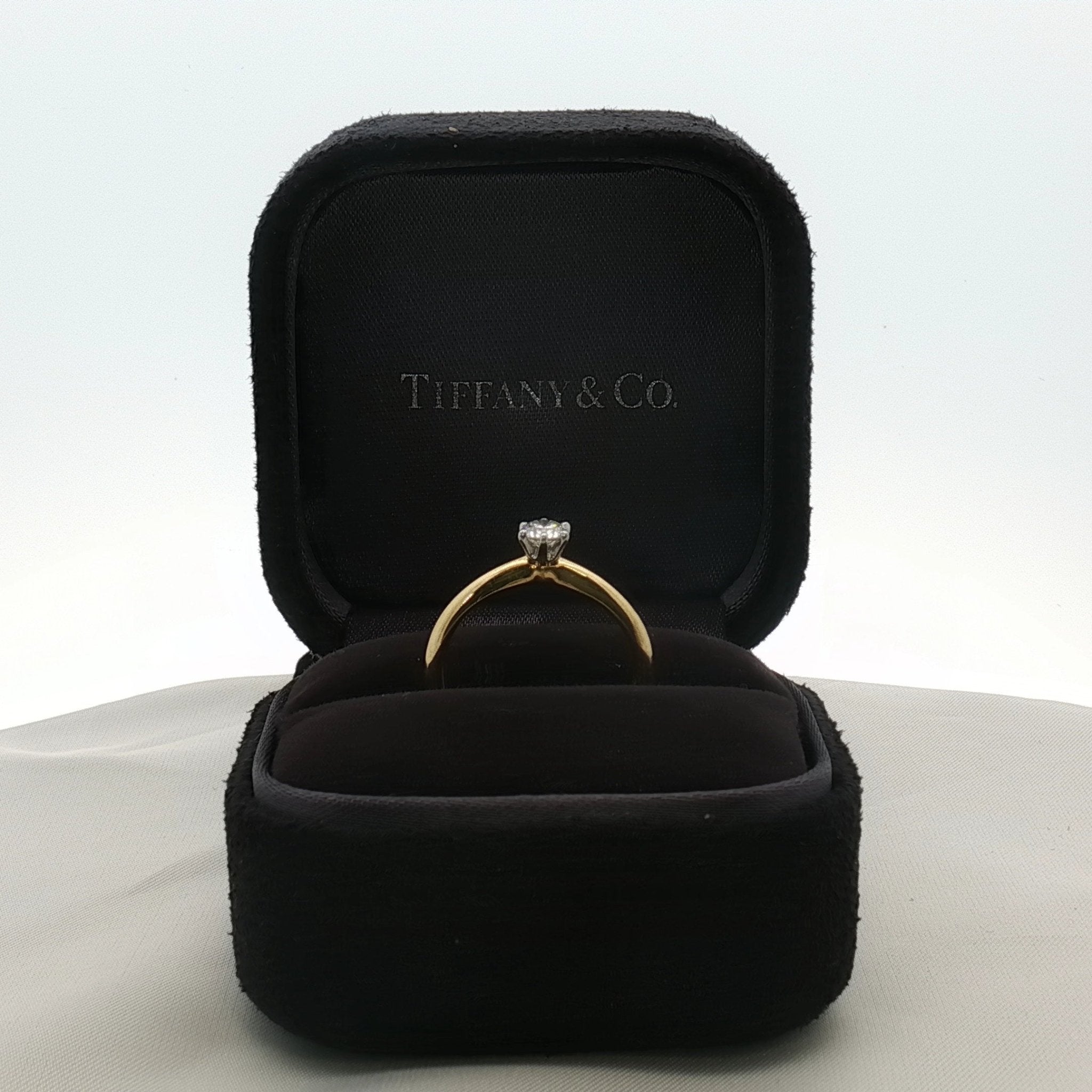 Gold & Beyond Tiffany & Co. classic solitaire diamond jewelry ring with a single sparkling diamond on a sleek band.