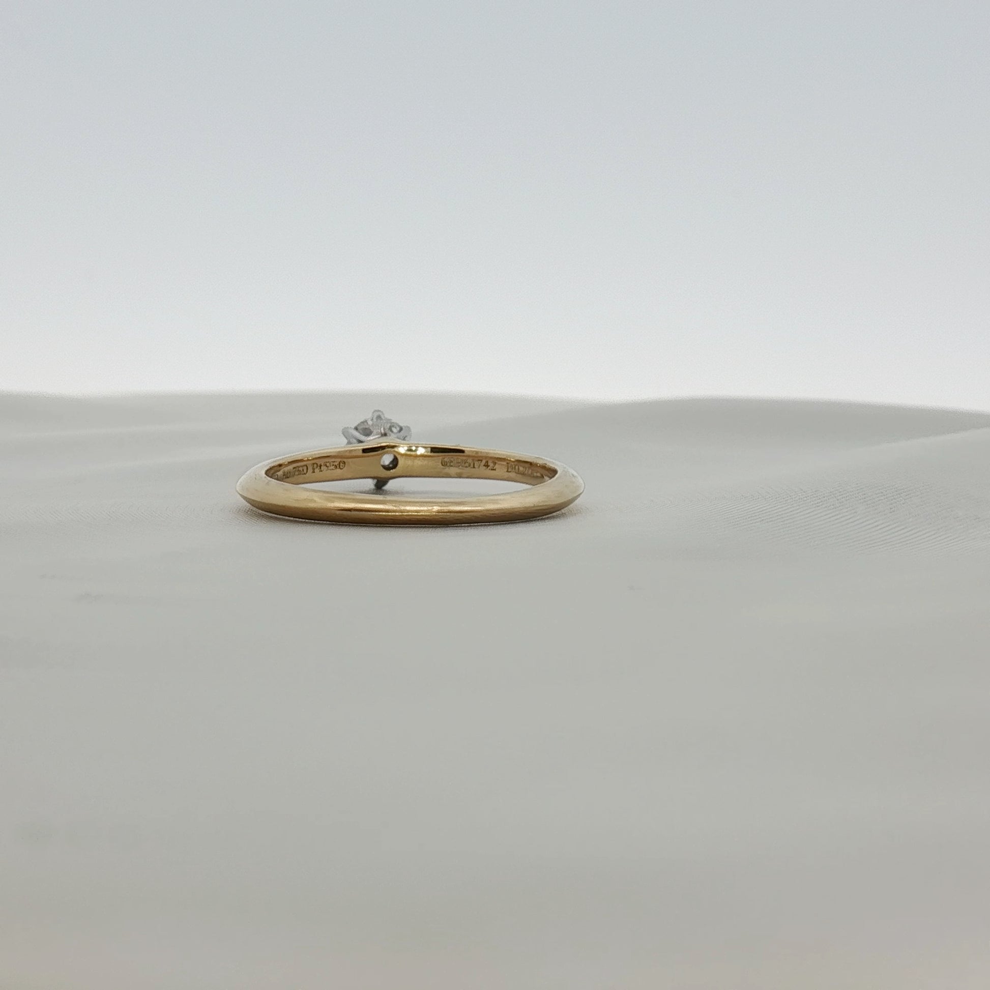 Gold & Beyond Tiffany & Co. classic solitaire diamond ring featuring a single sparkling diamond on a sleek band.