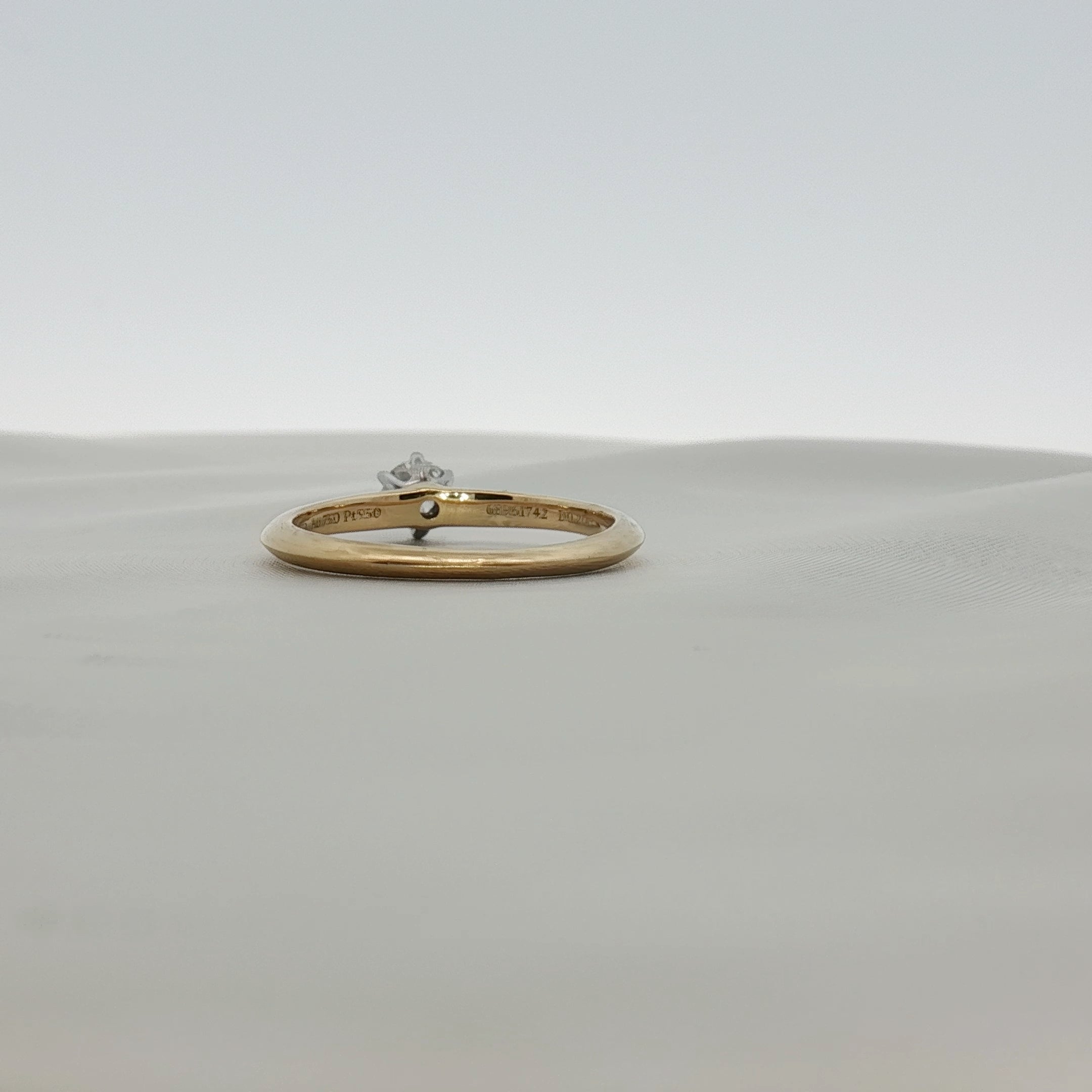 Gold & Beyond Tiffany & Co. classic solitaire diamond ring featuring a single sparkling diamond on a sleek band.