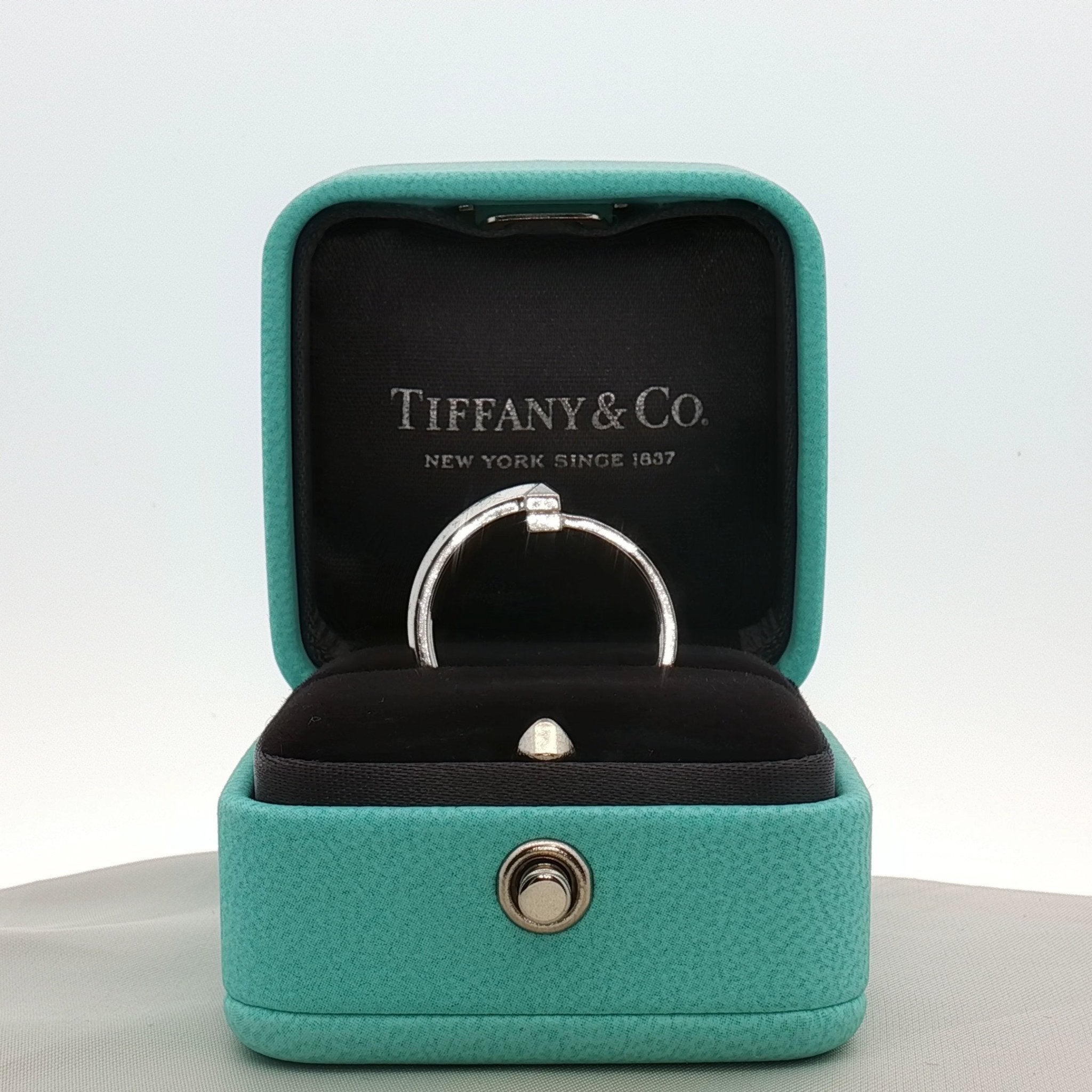 Gold & Beyond Tiffany & Co. Return to Tiffany T diamond ring showcasing a silver band with engraved logo and sparkling diamond accents