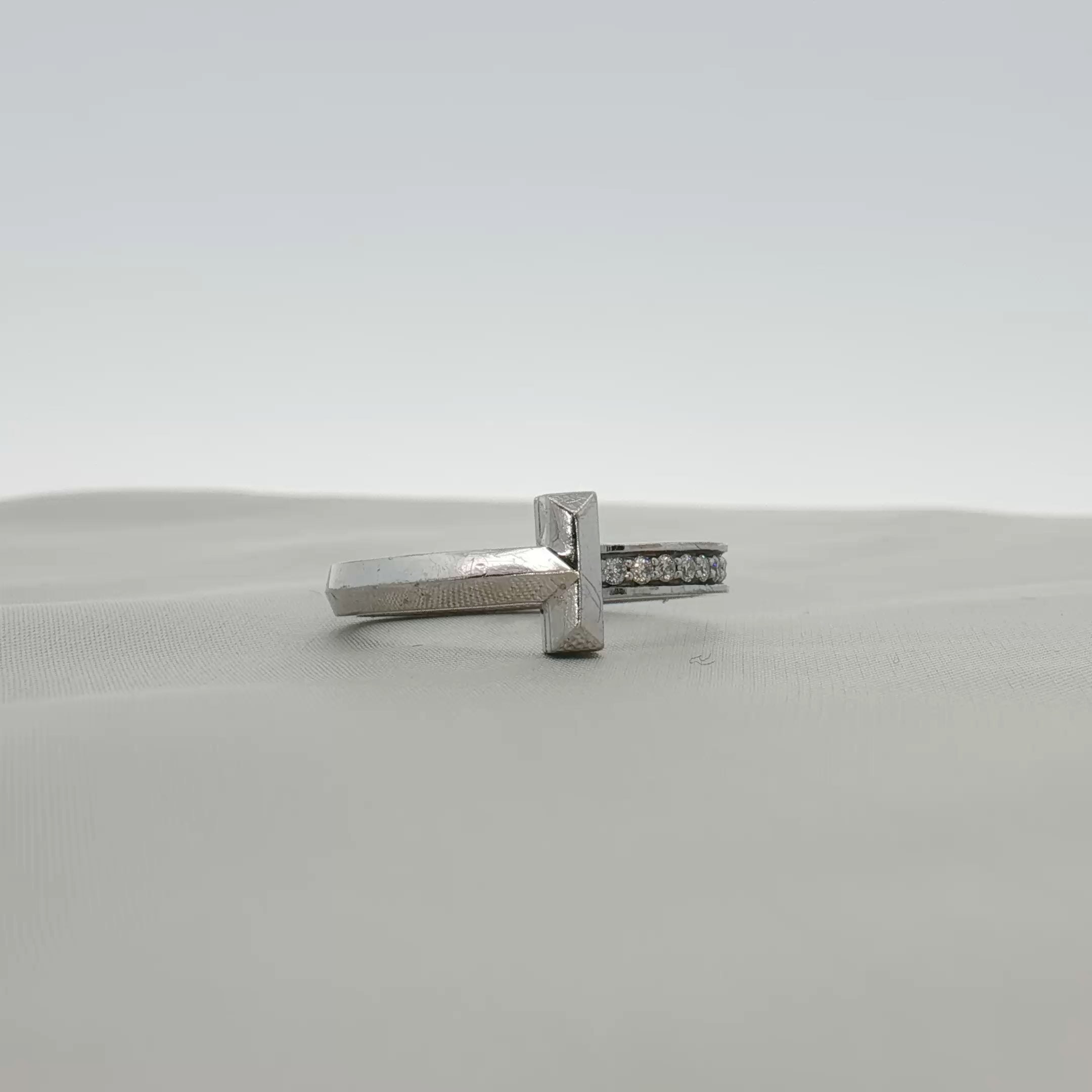 Gold & Beyond Tiffany & Co. Return to Tiffany T diamond ring showcasing a silver band with engraved logo and sparkling diamond accents.