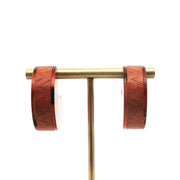 Louis Vuitton tortoise resin hoop earrings, stylish jewelry with gold accents, featuring a classic round hoop design.