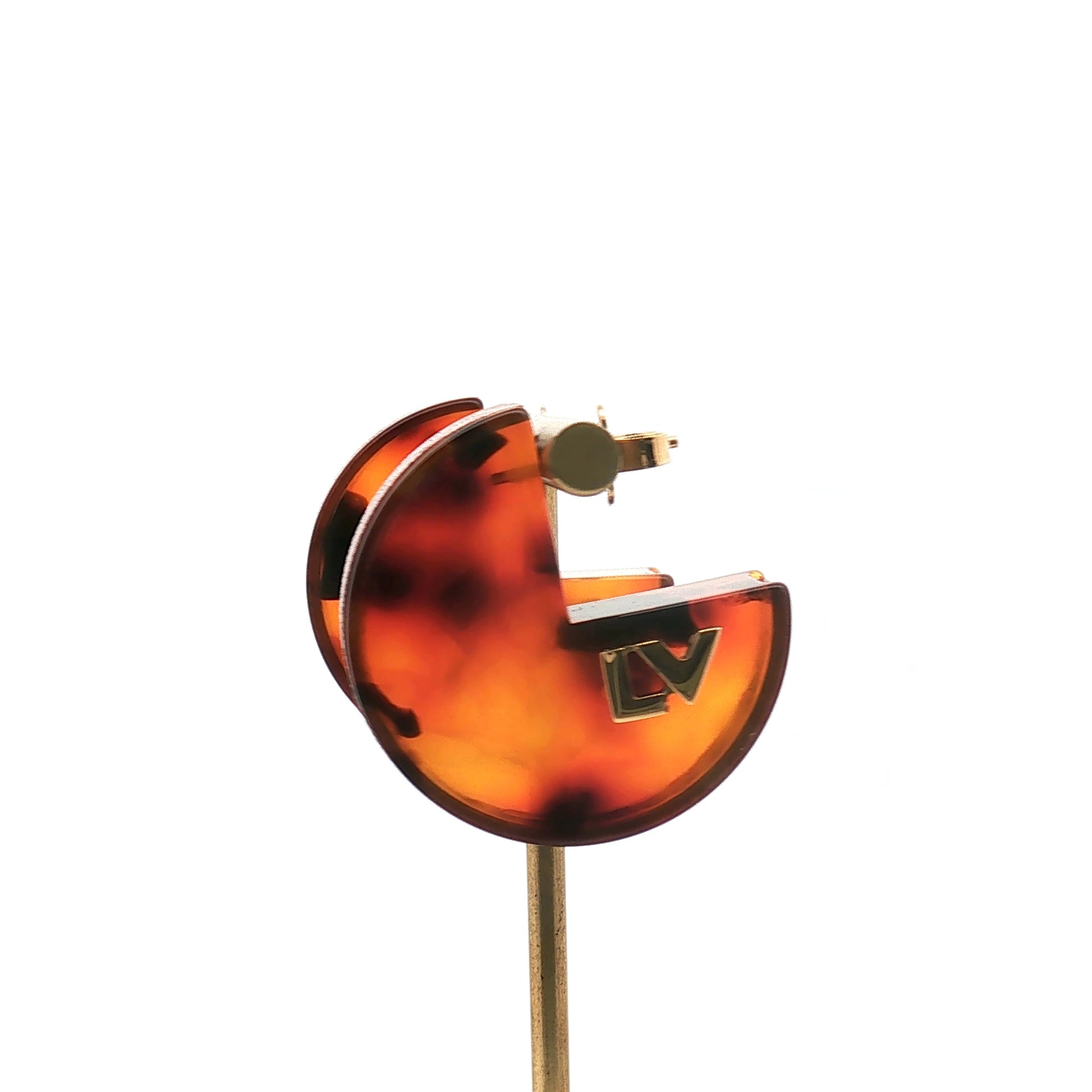 Louis Vuitton tortoise resin hoop earrings, stylish jewelry with a circular design and tortoise pattern, on a white background.