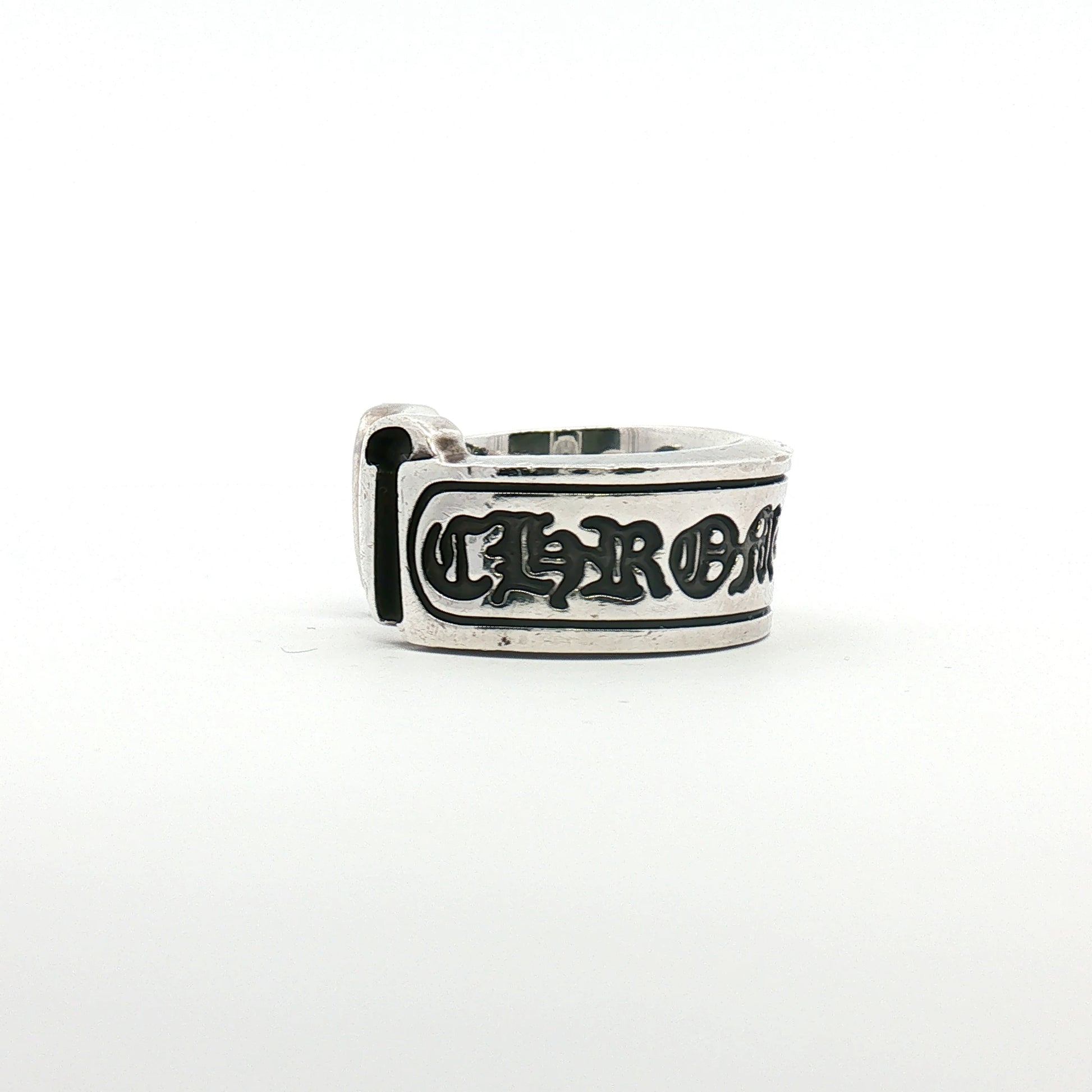 Chrome Hearts Scroll Logo Ring, gold jewelry with intricate scroll design, displayed on a neutral background.
