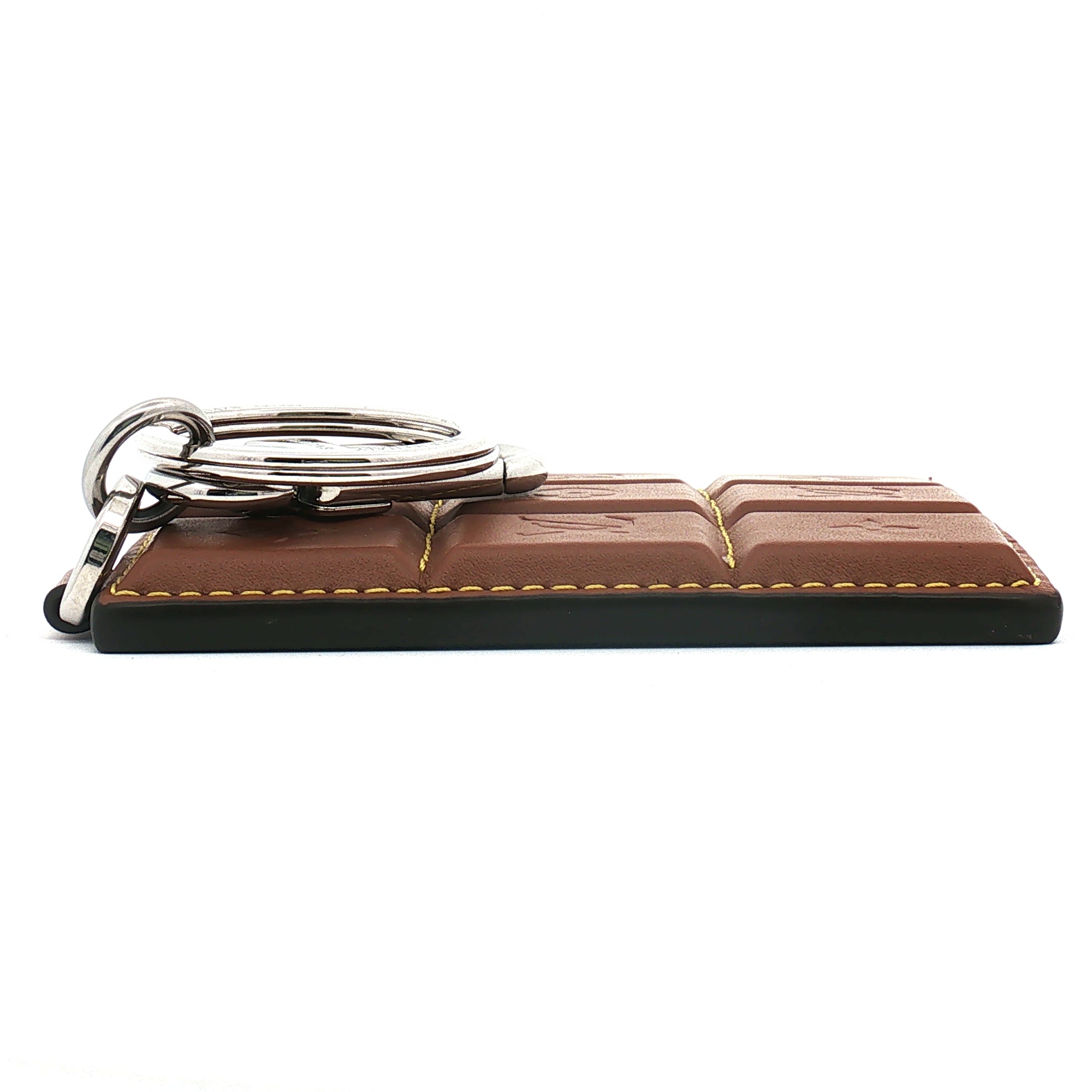 Louis Vuitton chocolate bar-shaped bag charm and key holder by Gold & Beyond, featuring detailed design and metallic accents.