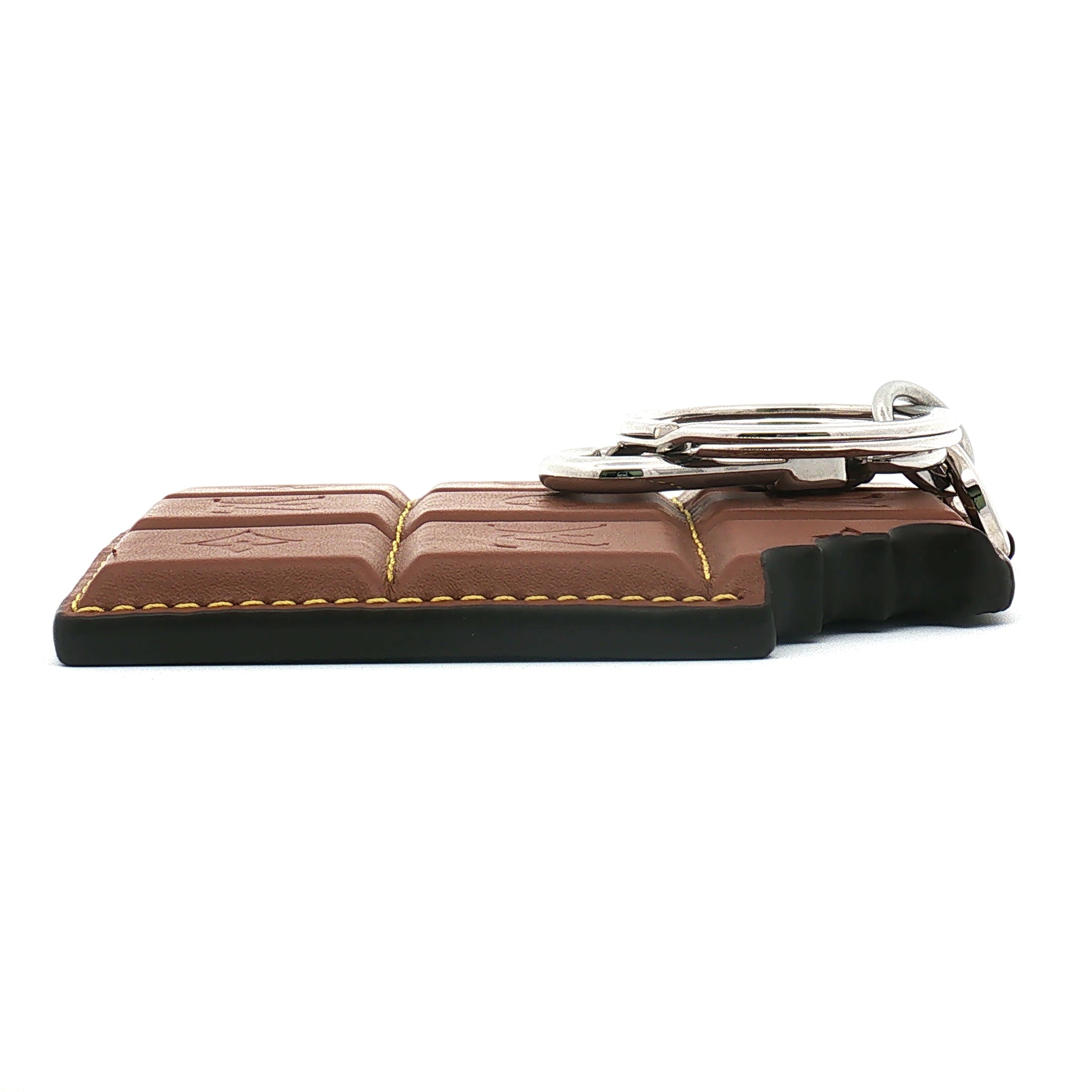 Louis Vuitton chocolate bar bag charm and key holder with gold accents, designed as a stylish accessories piece.