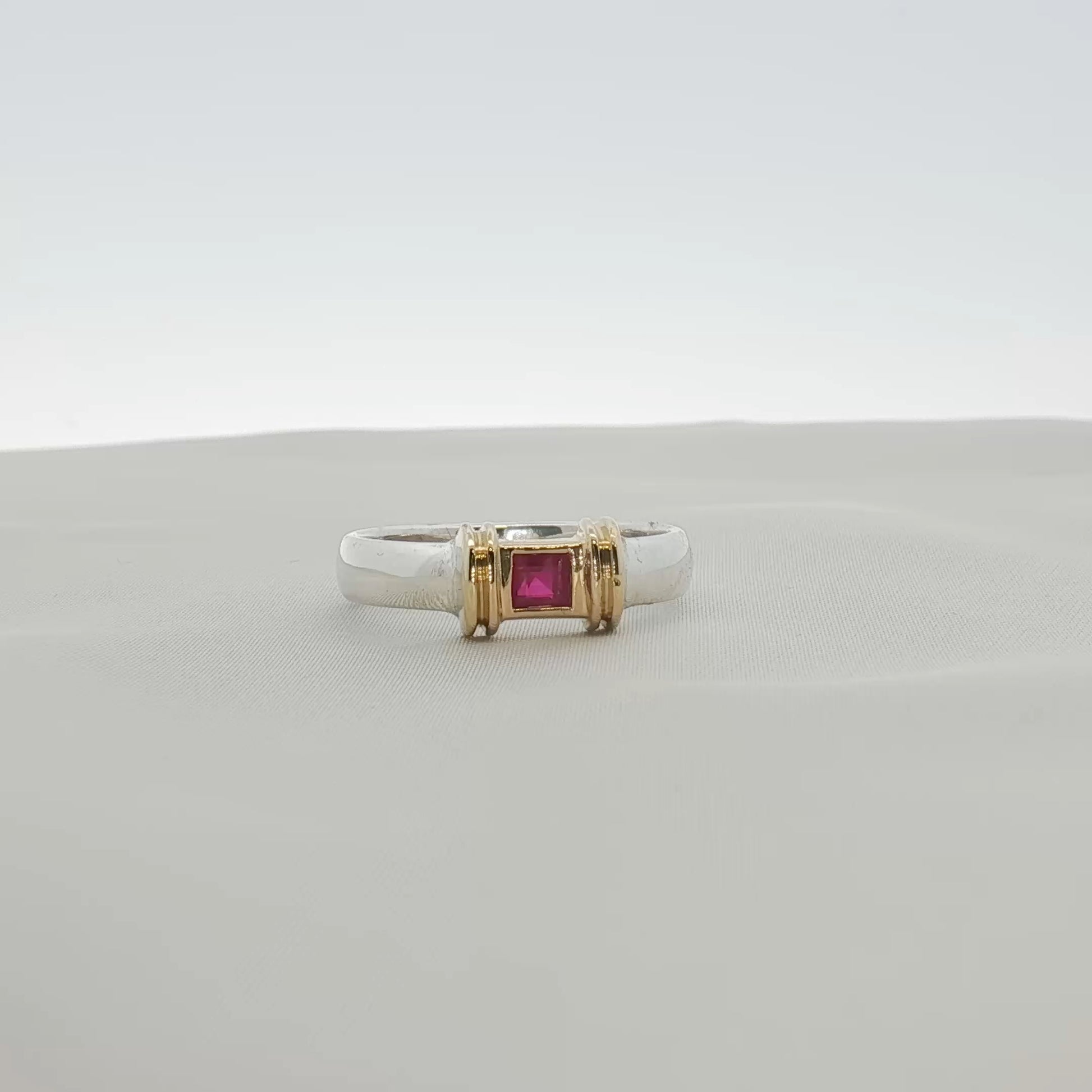 Tiffany & Co. two-tone sterling silver and 18K gold ruby ring with a polished finish, showcasing the elegant jewelry design.