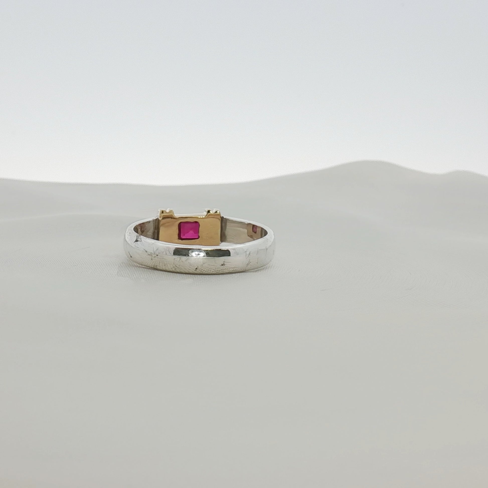 Tiffany & Co. two-tone sterling silver and 18K gold ruby ring with a polished band and vibrant red ruby gemstone.