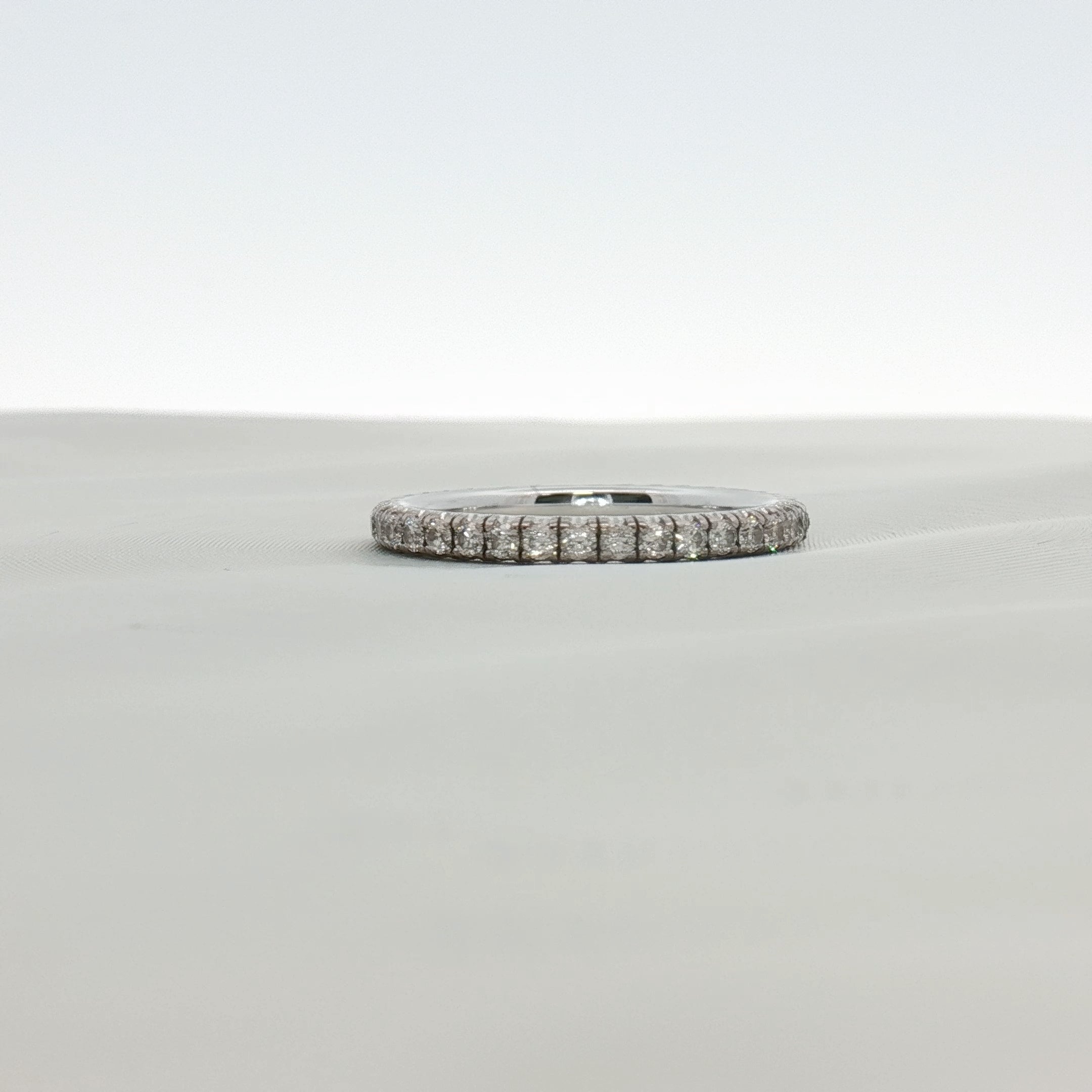 Cartier Love Eternity diamond band ring with gold setting, showcasing a continuous row of sparkling diamonds on a sleek jewelry piece.