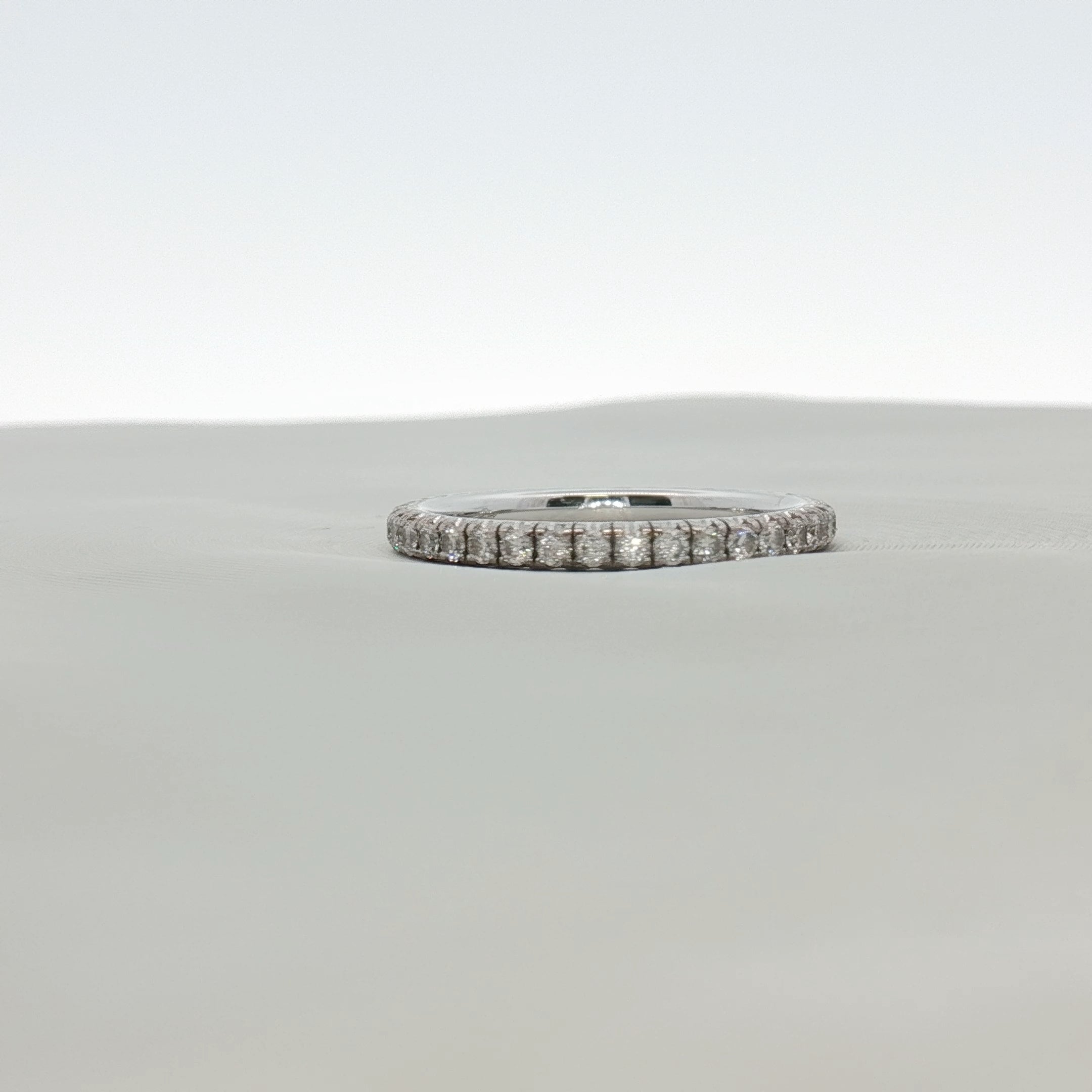 Cartier Love Eternity Diamond Band Ring featuring a gold band with sparkling diamonds, showcasing a luxurious jewelry design.